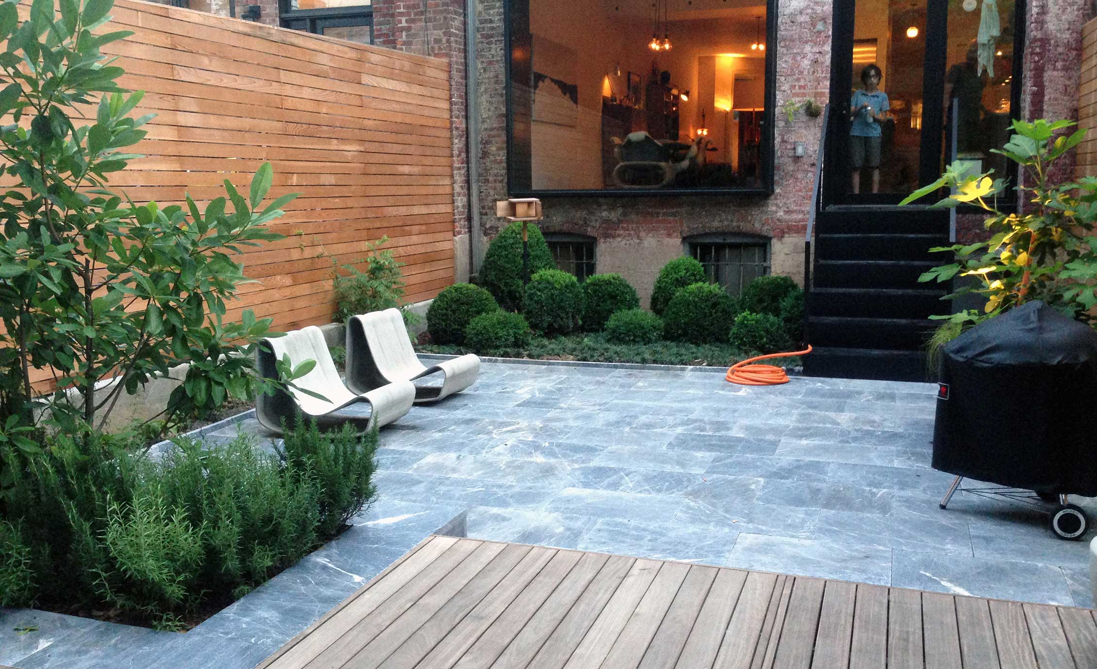 For this Brooklyn townhouse, Klausing surrounded the marble patio with flowering dogwood trees, sculpted boxwoods and mondo grass.