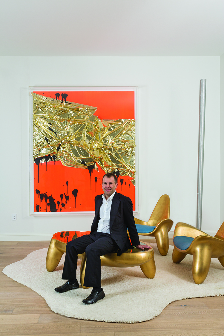 George Lindemann with a Wendell Castle coffee table and chairs an untitled work by Anselm Reyle is on the wall.