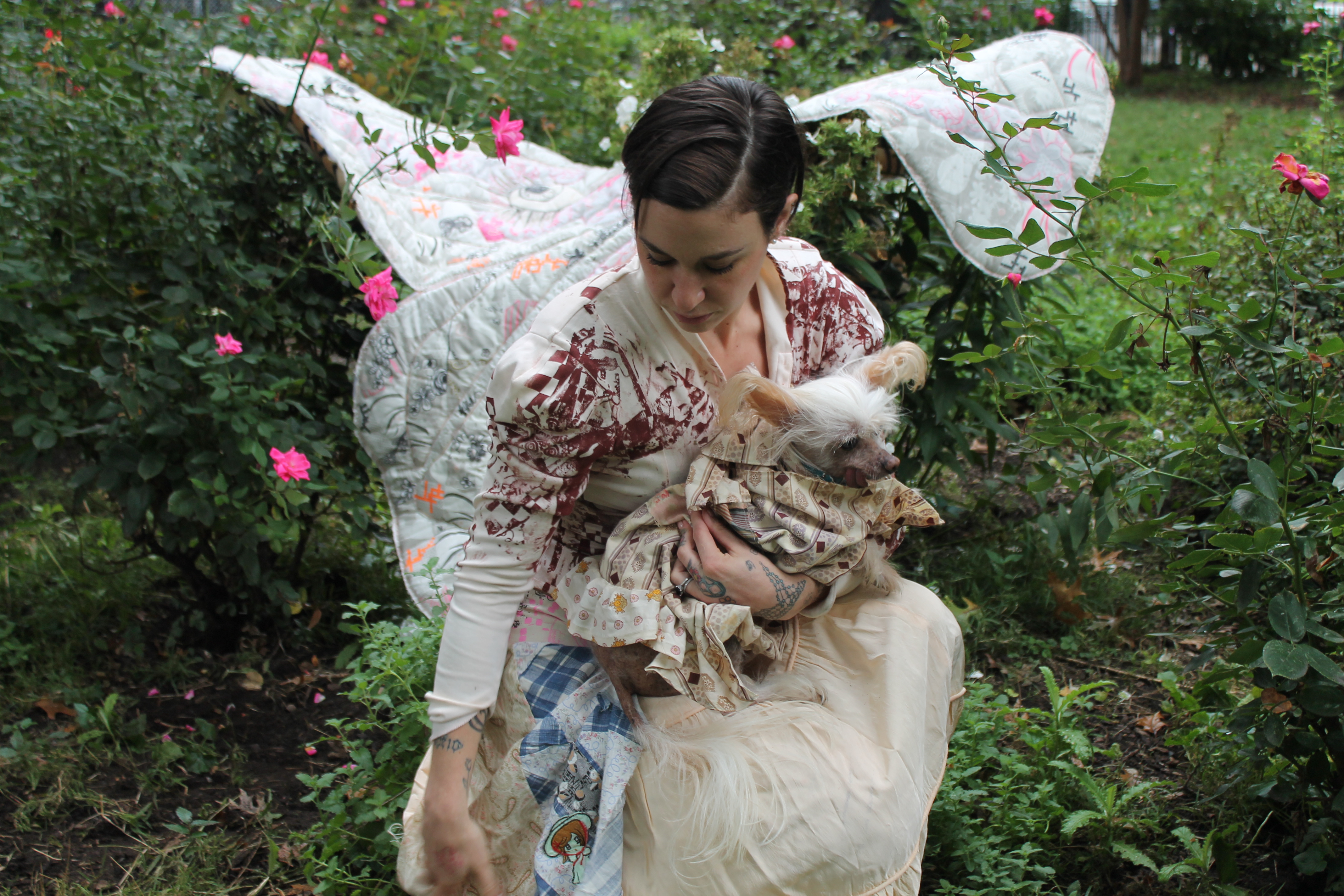 Trabulus and her dog, Misty, take a picnic in Tompkins Square Park both wearing garments by Women's History Museum, 2018. 