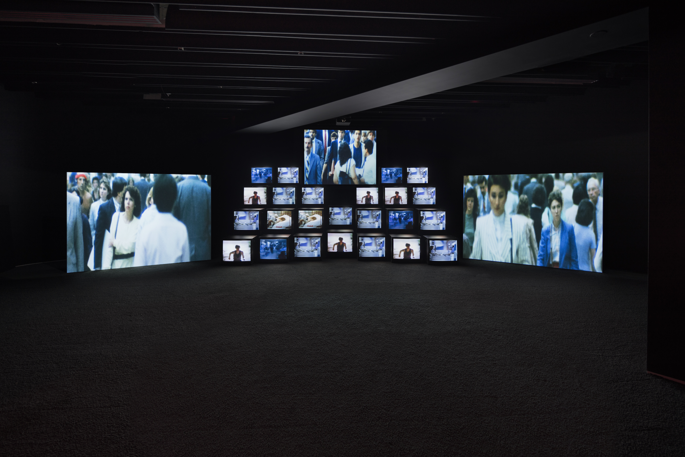 'Total Recall', 1987. 11-channel video installation on 24 monitors and 3 projection screens, 18.2 minutes, with soundtrack by Stuart Argabright. Installation view of 'Gretchen Bender: So Much Deathless' at Red Bull Arts New York, 2019. Photo by Lance Brewer. All artwork © The Gretchen Bender Estate. 