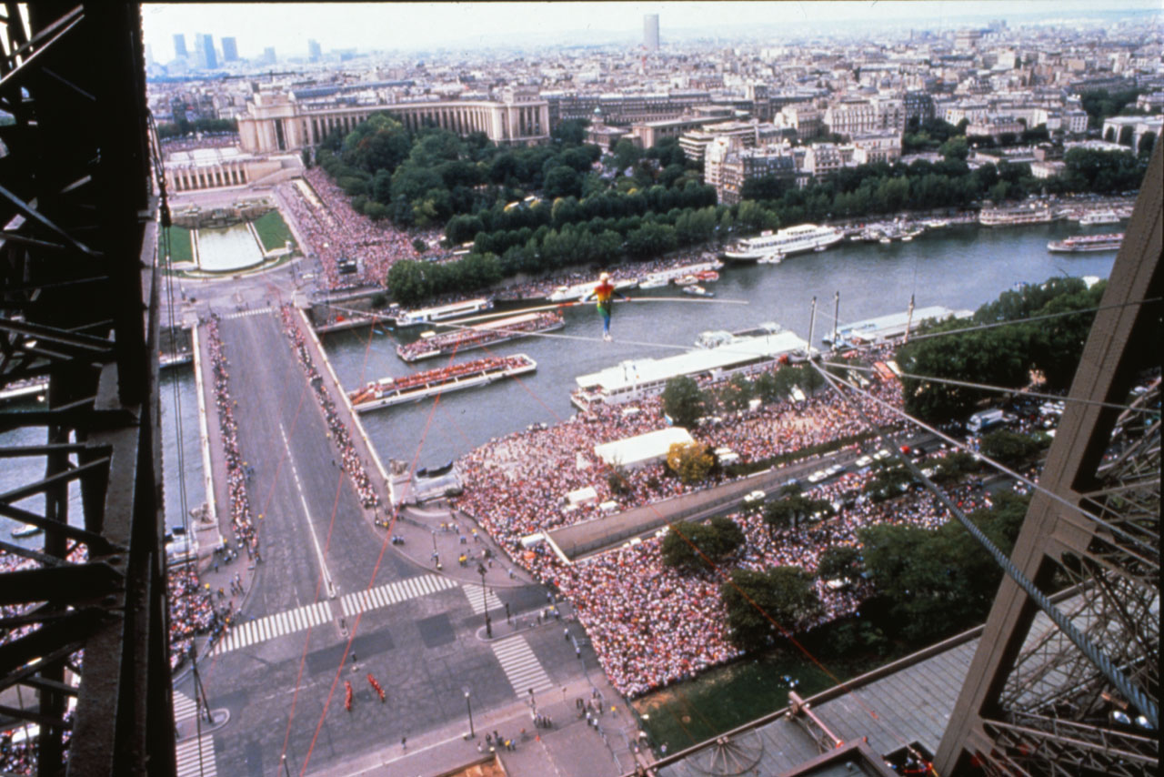 In front of 250,000 people Philippe concludes his 700 yards long inclined walk to the second story of the Eiffel Tower, in 1989. Courtesy of Michael Kerstgens/Collection Philippe Petit.