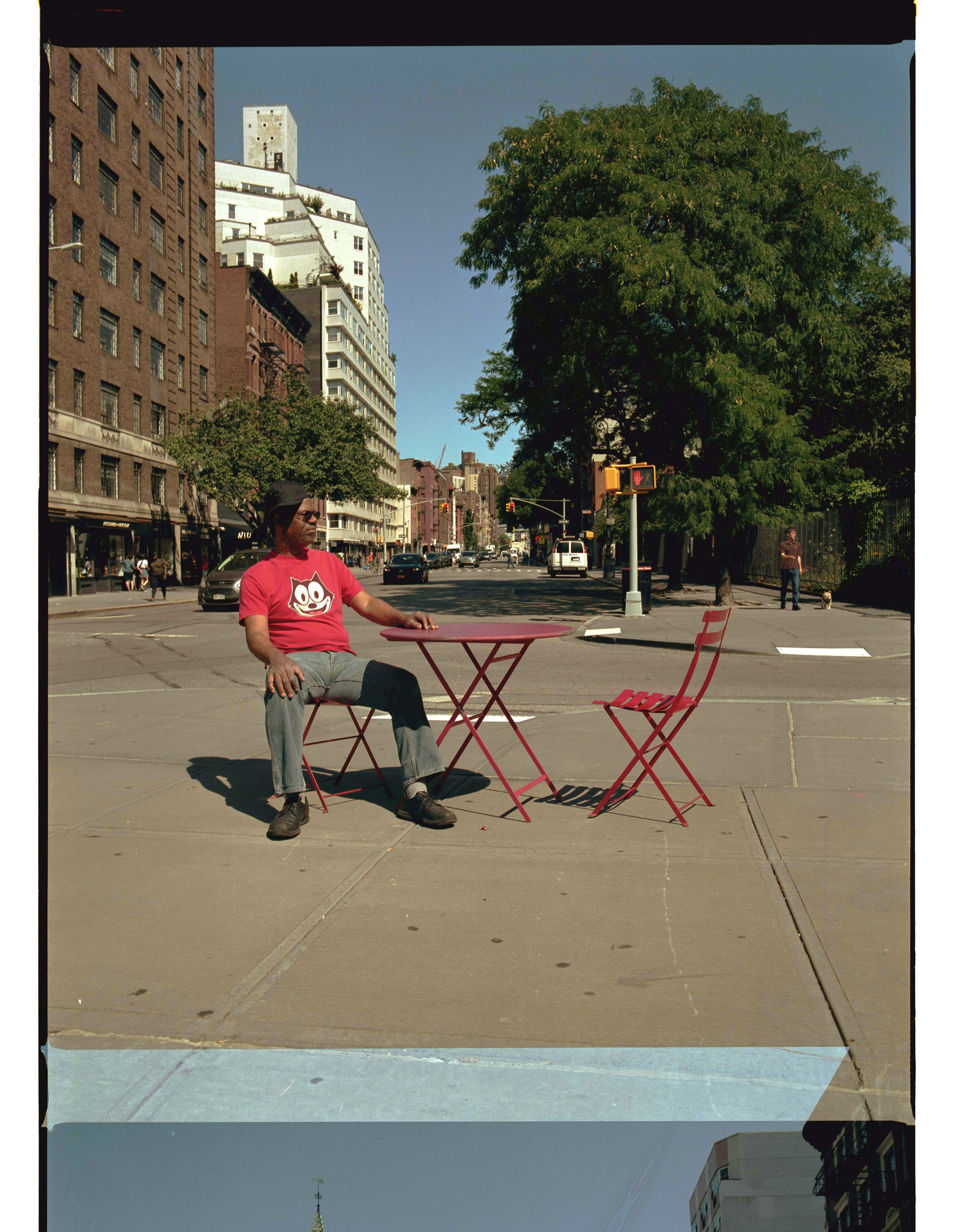 Pope.L on an August morning, sitting along the route of his fall crawl. Image Courtesy of Damien Fry.