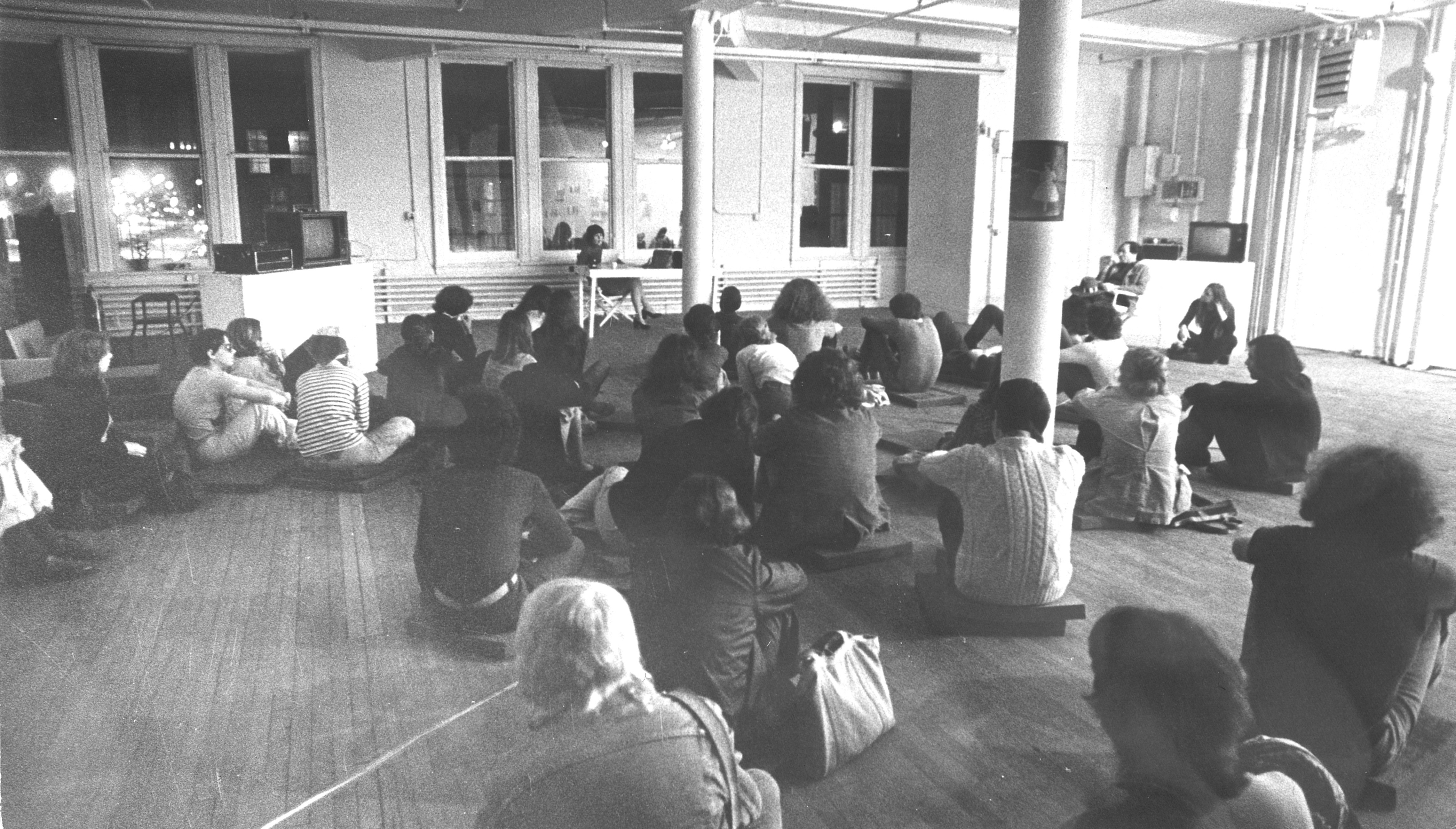 Audience gathered for a poetry reading by Jennifer Bartlett, April 23, 1974, as part of “PersonA,” a performance and film series curated by Edit deAk for Artists Space, April 23 – April 26, 1974. 
