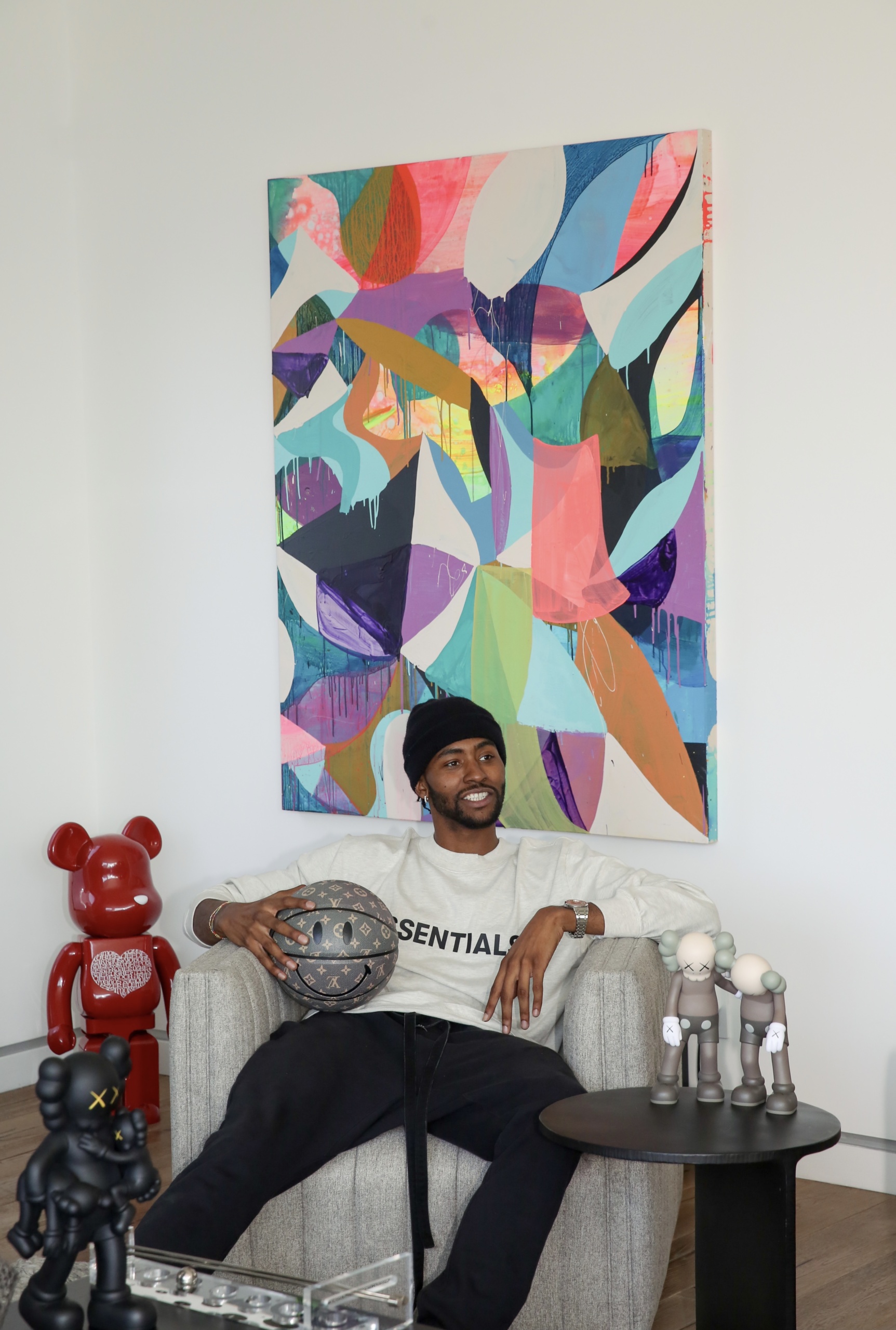 Miami Heat basketball star Moe Harkless at home in Los Angeles, featuring his collection of Kaws and BE@RBRICK statues and Maya Hayuk's painting Flow Chart.