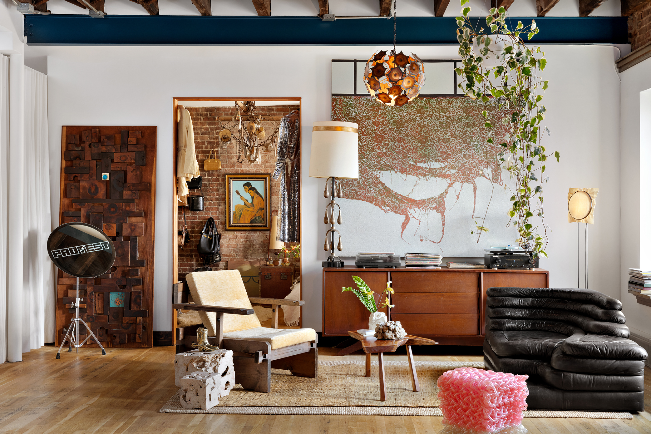 Erin Wasson's New York home. Wooden door by Doyle Lane, Ivan Navaro cymbal sculpture, pink stool by Kwangho Lee and art by Mark Flood above console.