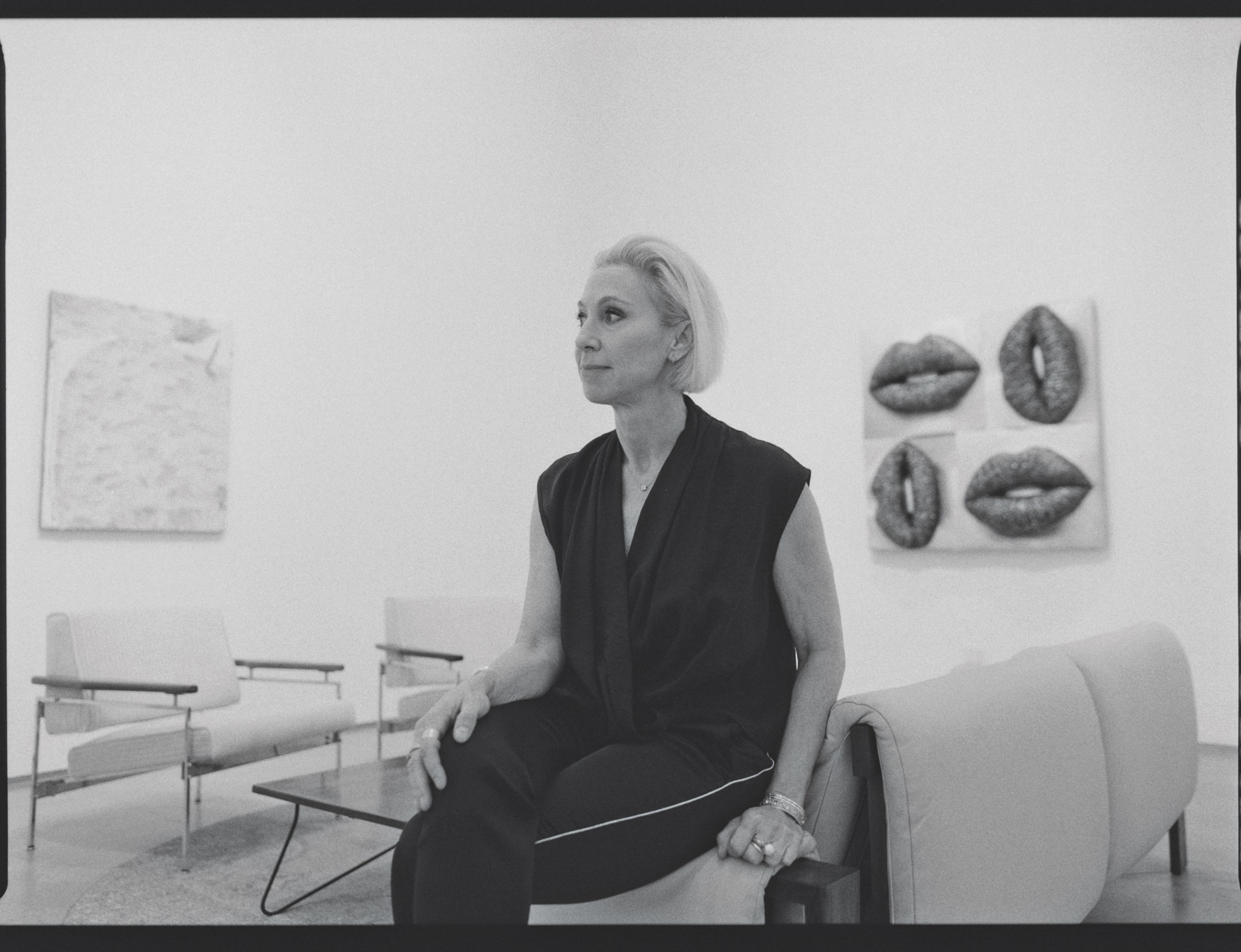 Black and white image of art gallerist sitting in her office space, side profile