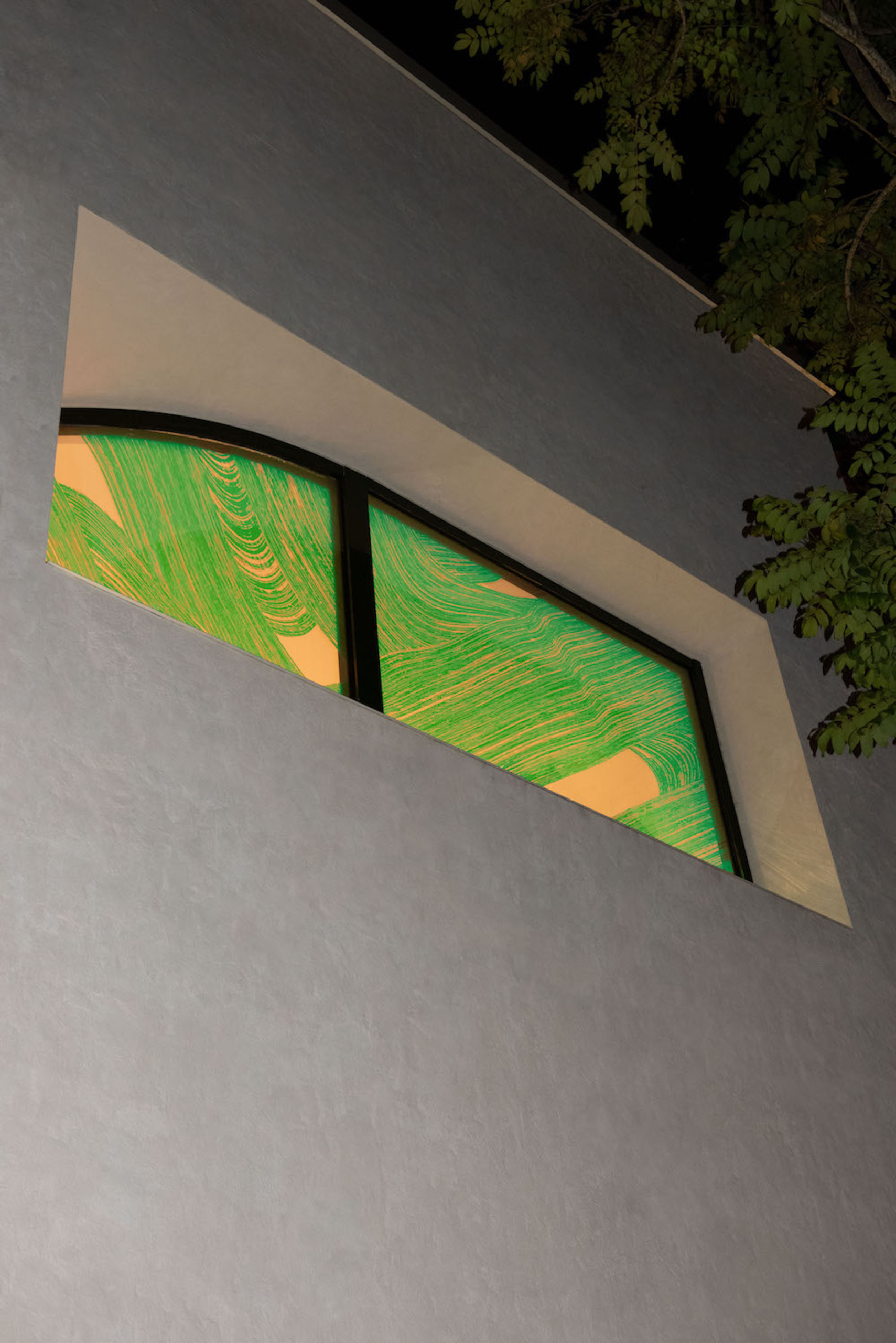 Dark storefront illuminated by window with knotlike pattern embossed on glass