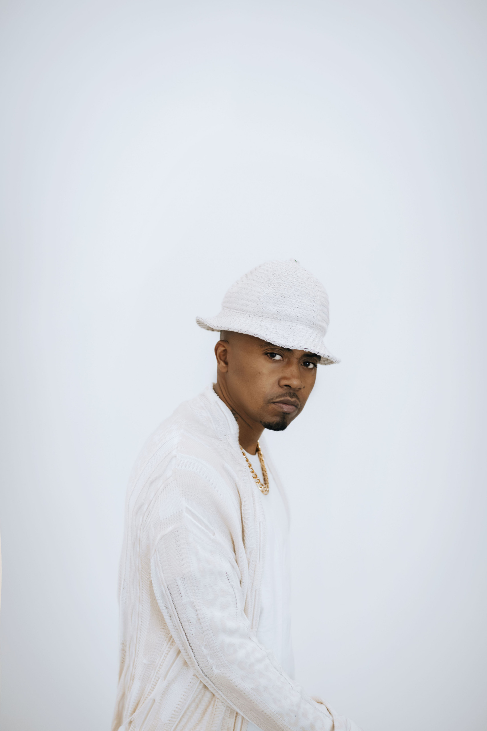 Musician in white cap and jacket against white background