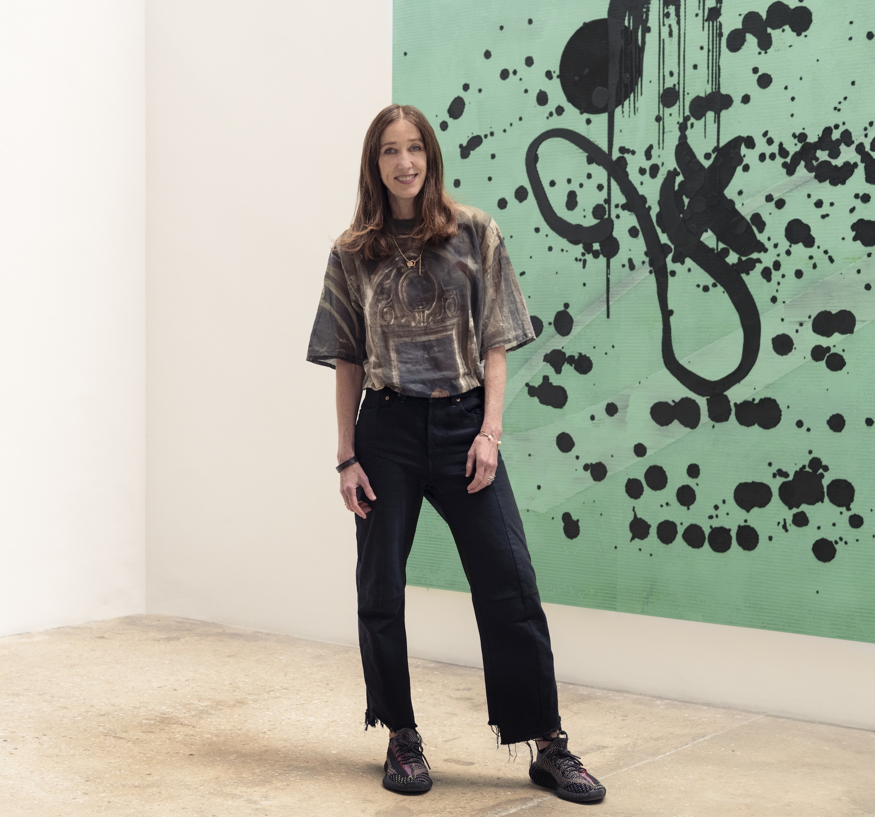 Female art gallerist standing in front of abstract painting