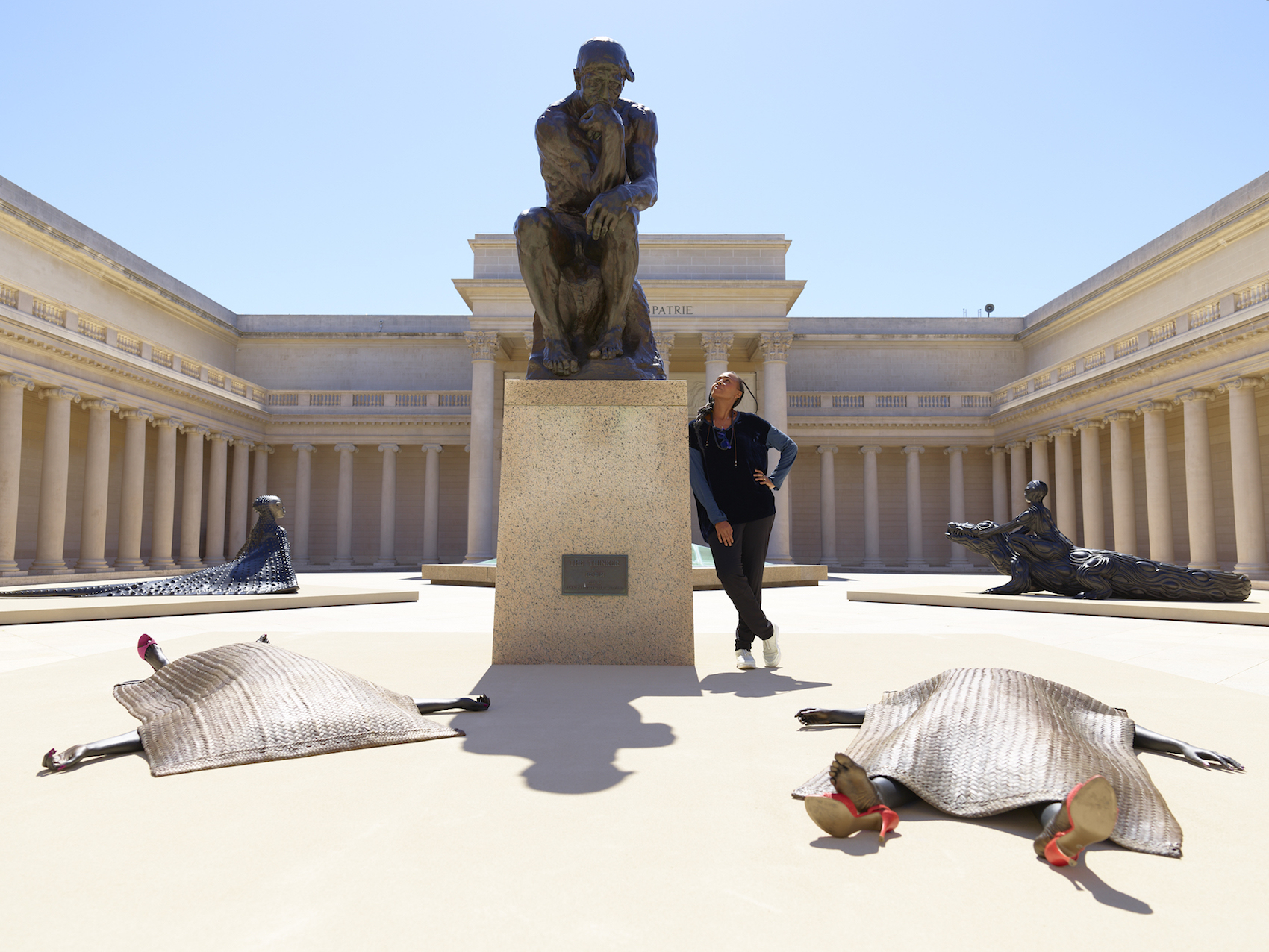 Wangechi Mutu poses with Rodin’s The Thinker (1880) and her sculptural installation in the outdoor courtyard of San Francisco’s Legion of Honor Museum. Portrait by Randy Dodson.