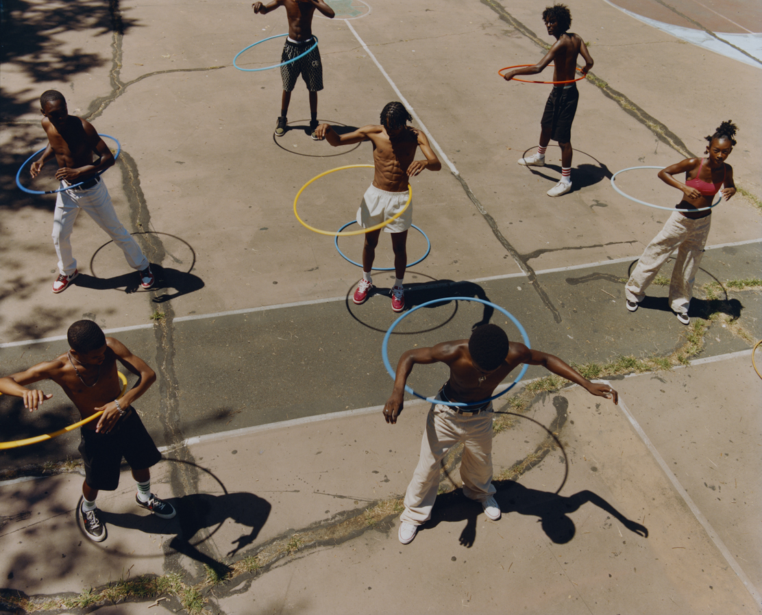 Photo of young men hoola hooping on basketball court