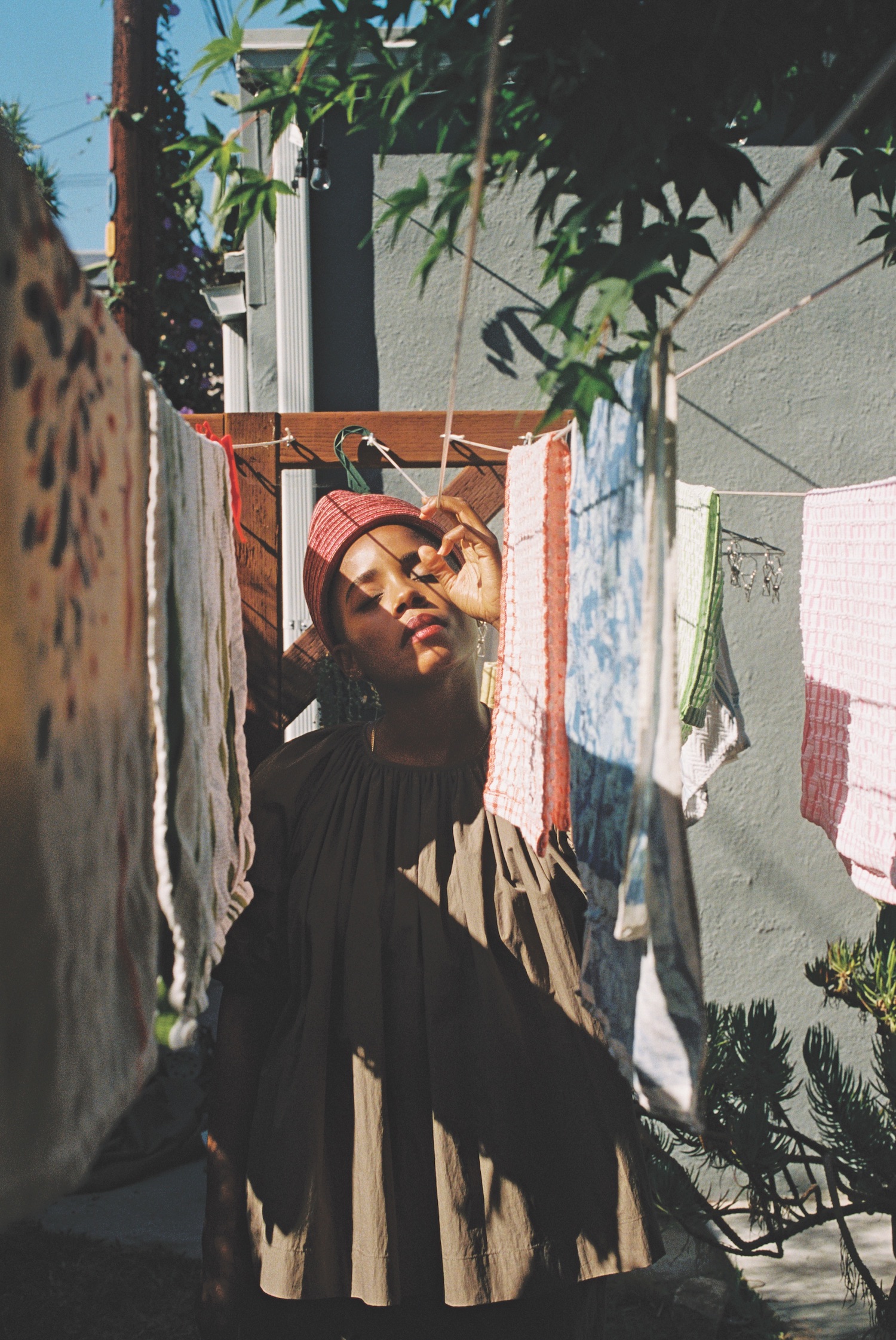 Janicza Bravo wears CO Collections two-piece suit and Esenshel hat in her backyard. Makeup by Toby Fleischman.