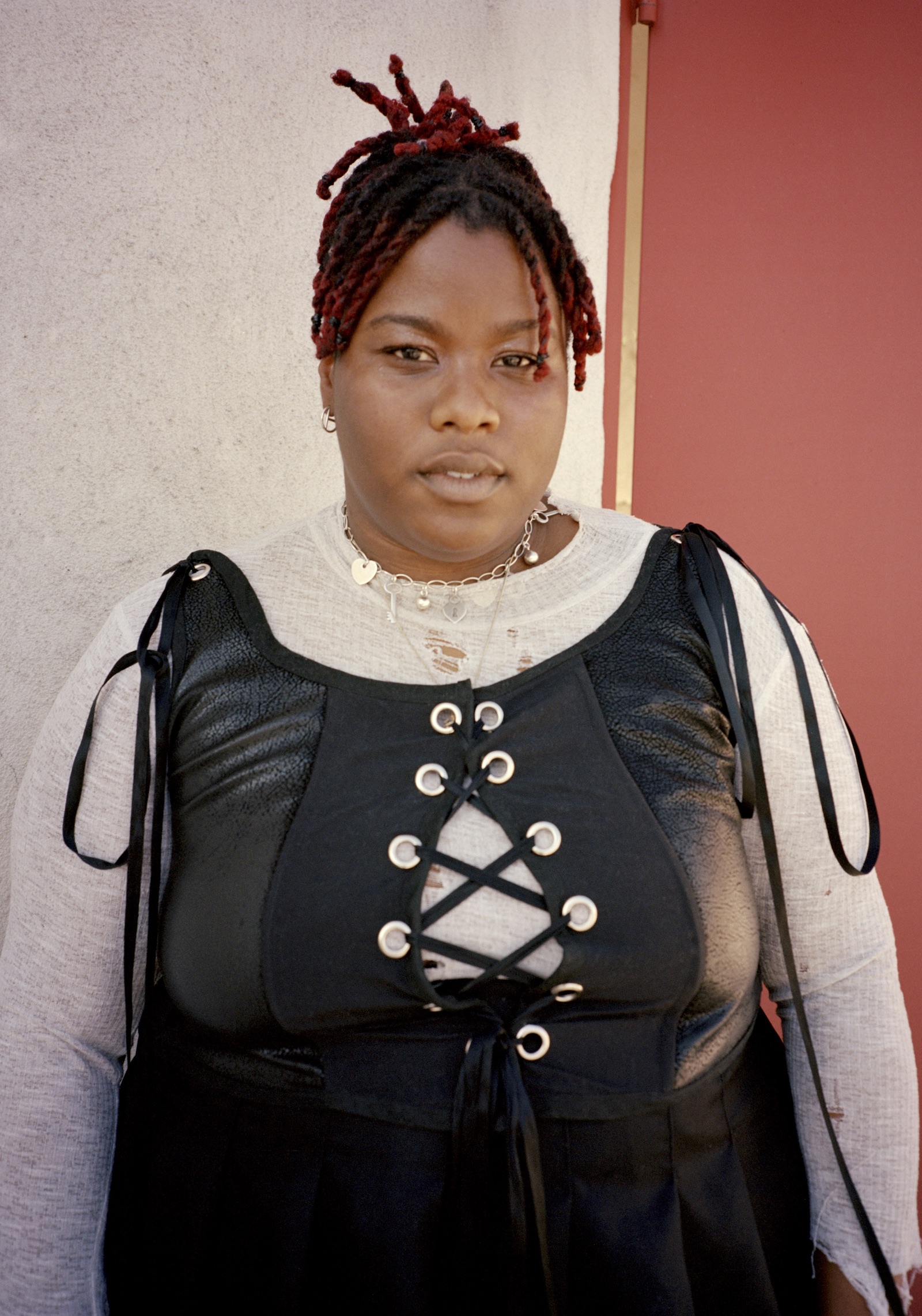 Portrait of young woman with red braids and in leather corset 