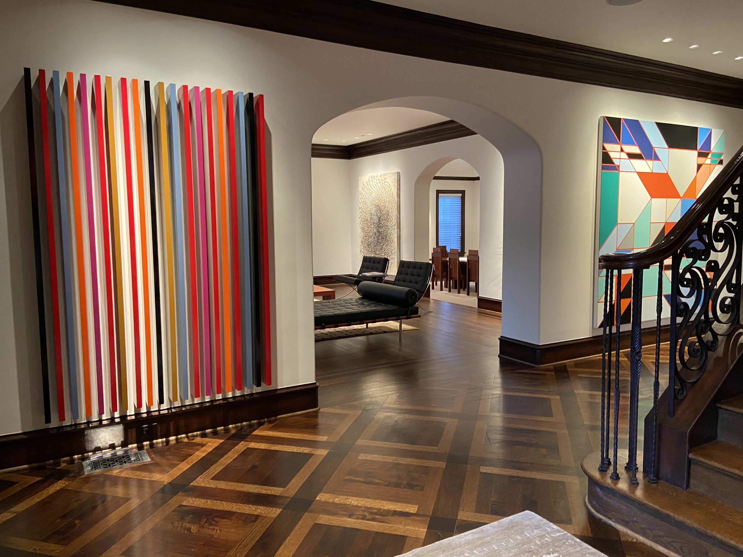 art collector's foyer with glimpse into living room space, with abstract artwork on walls Mark Giambrone