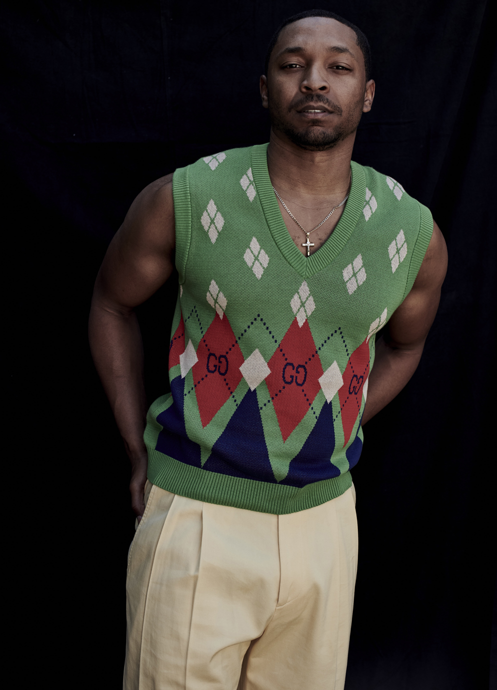 portrait of man in Gucci sweater vest against opaque background