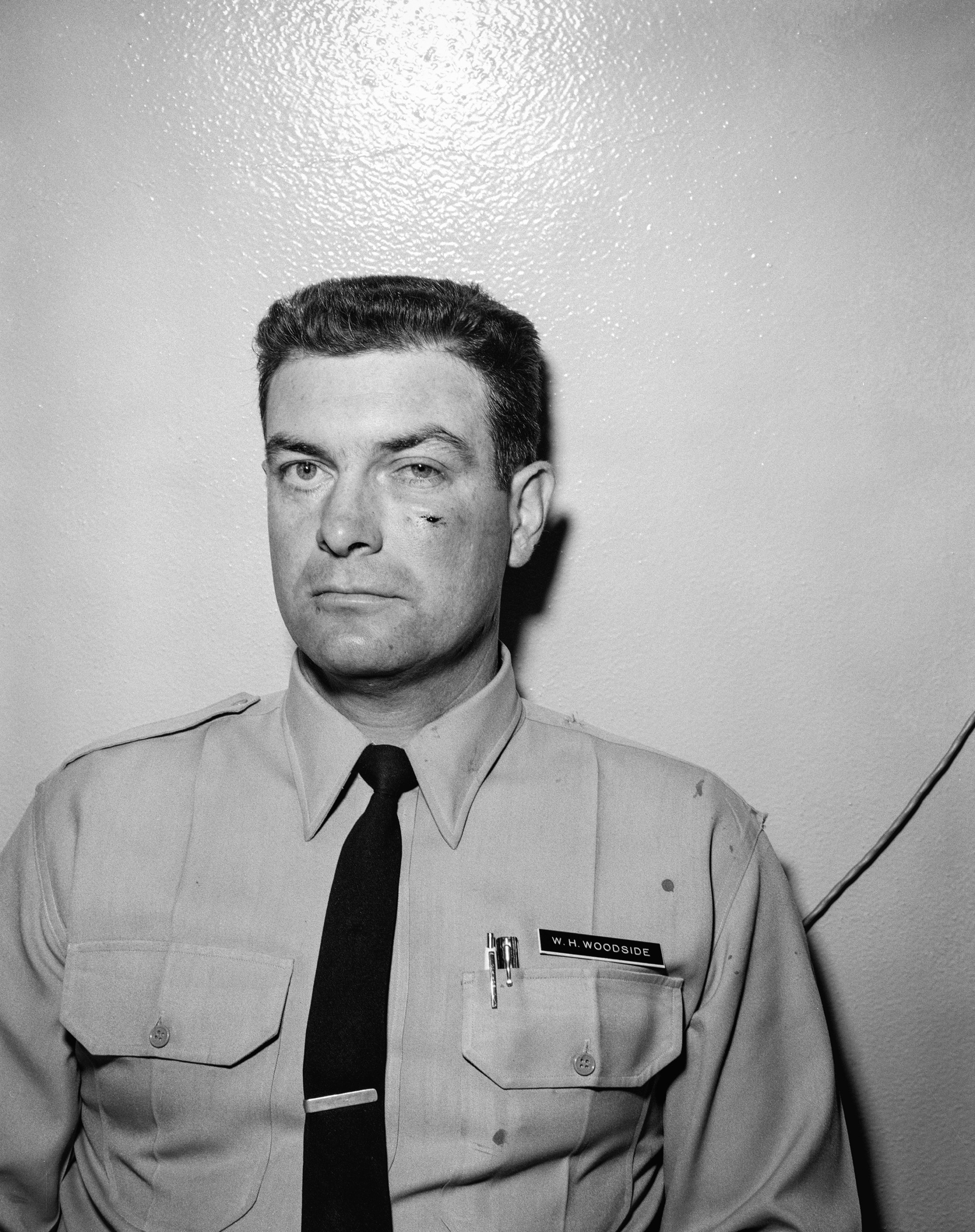 portrait of corrections officer standing against the wall