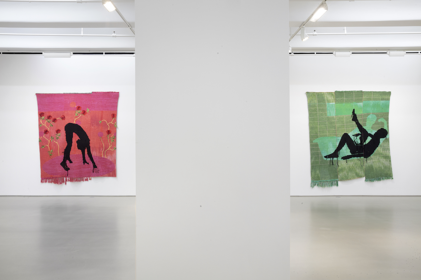 two textile print quilts by diedrick brackens in gallery space; two pieces depict silhouette figures against green and pink backgrounds