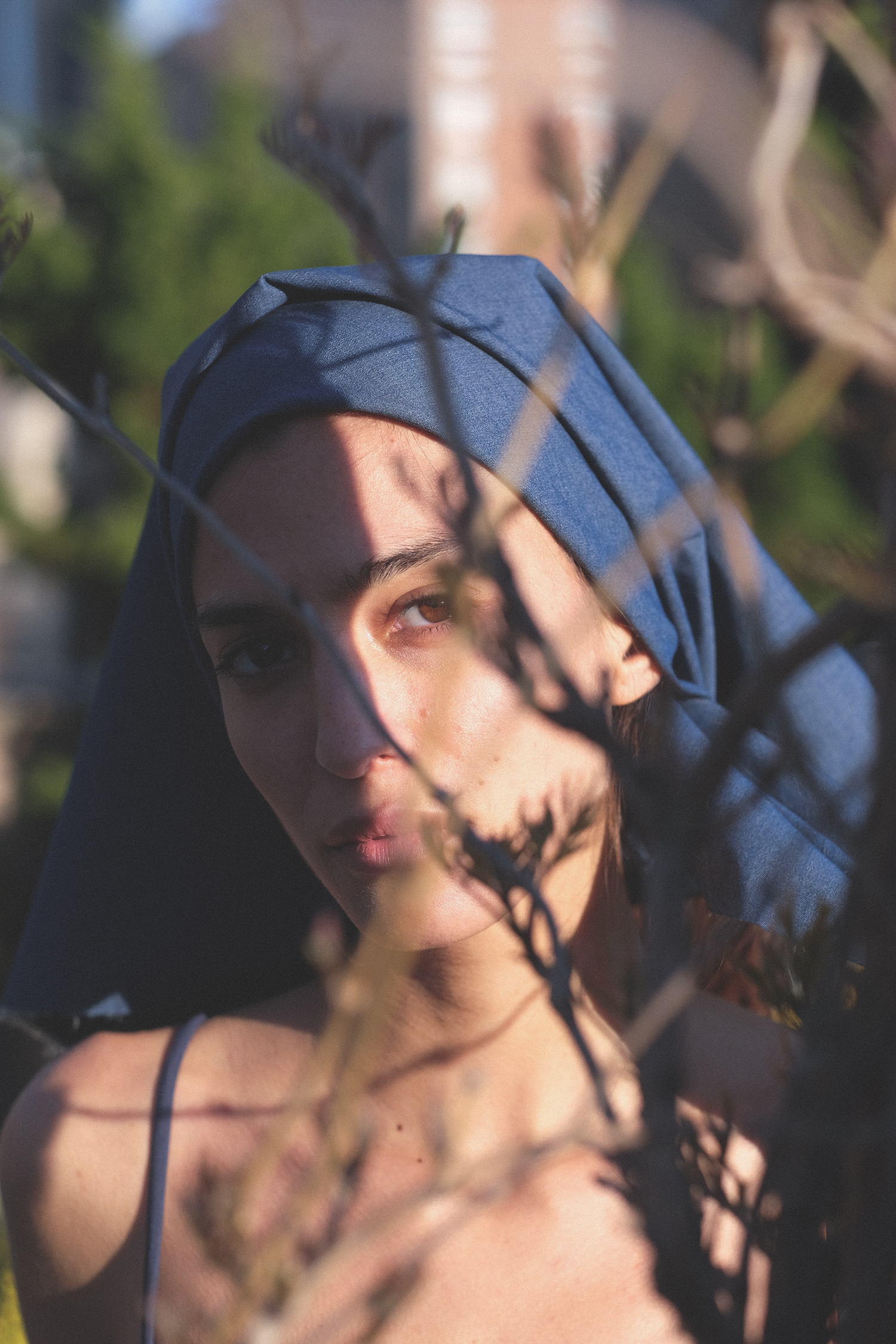 marina testino in isko denim headwrap behind branches of tree