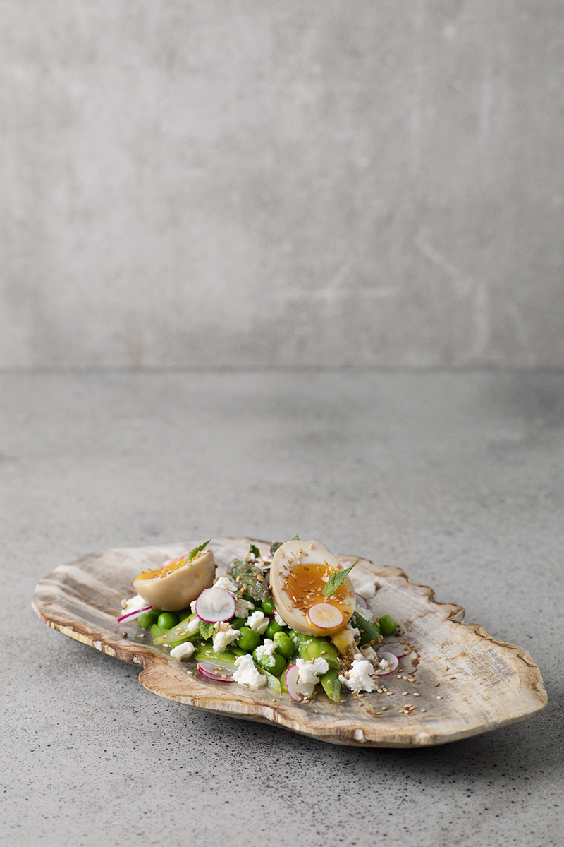 modern gourmet meal with eggs and edamame and radish on oyster-like wooden plate at paris restaurant FOREST