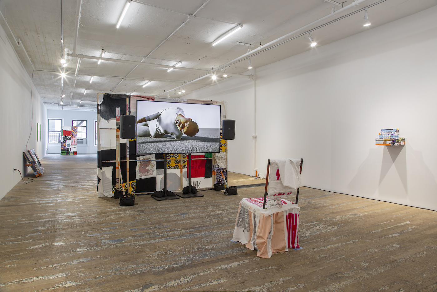 installation view of martine syms loot sweets, with makeshift tv theater made of textiles and objects in gallery space