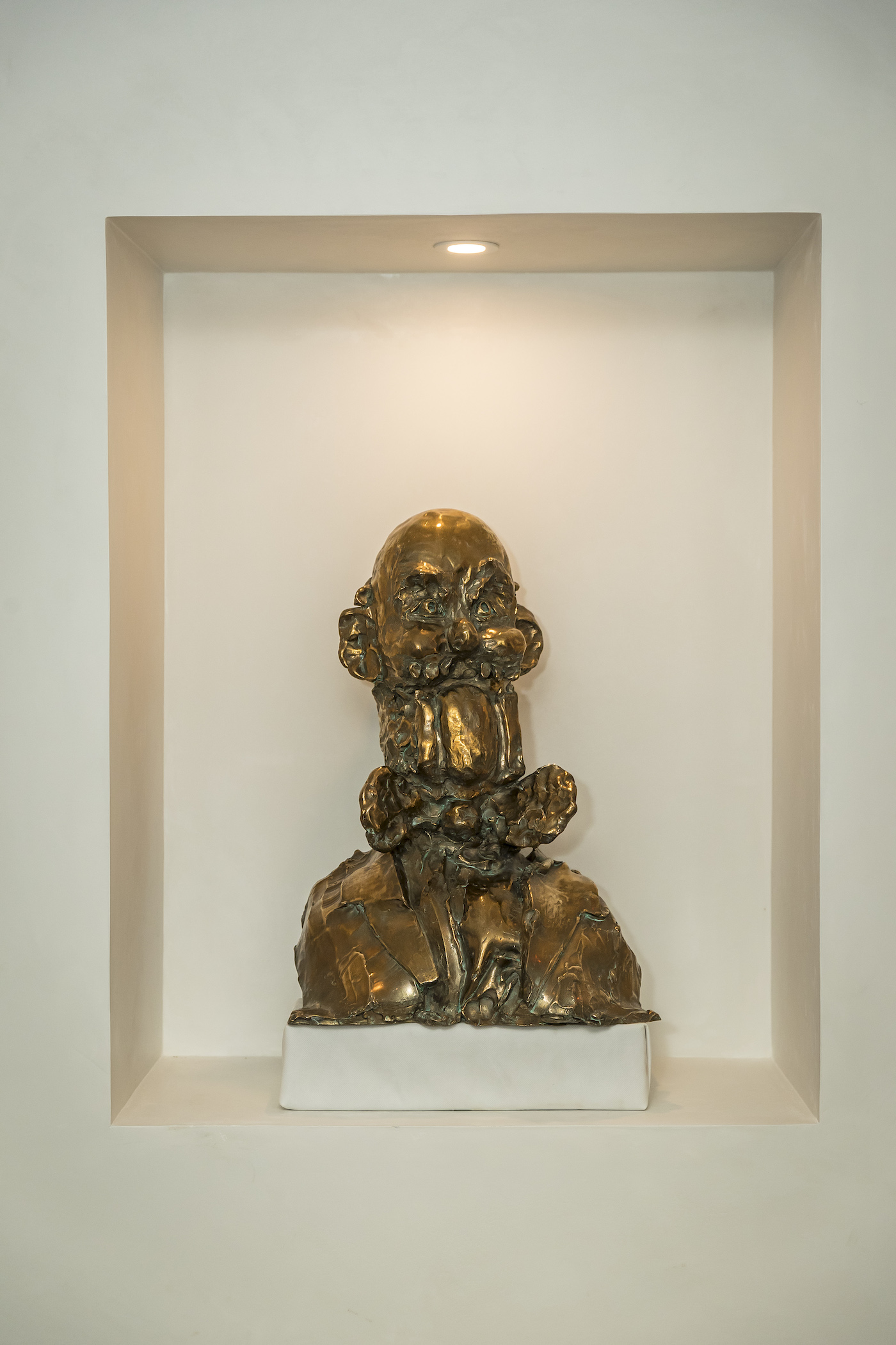 gold sculpture by george condo sits in wall nook in jamie tisch home