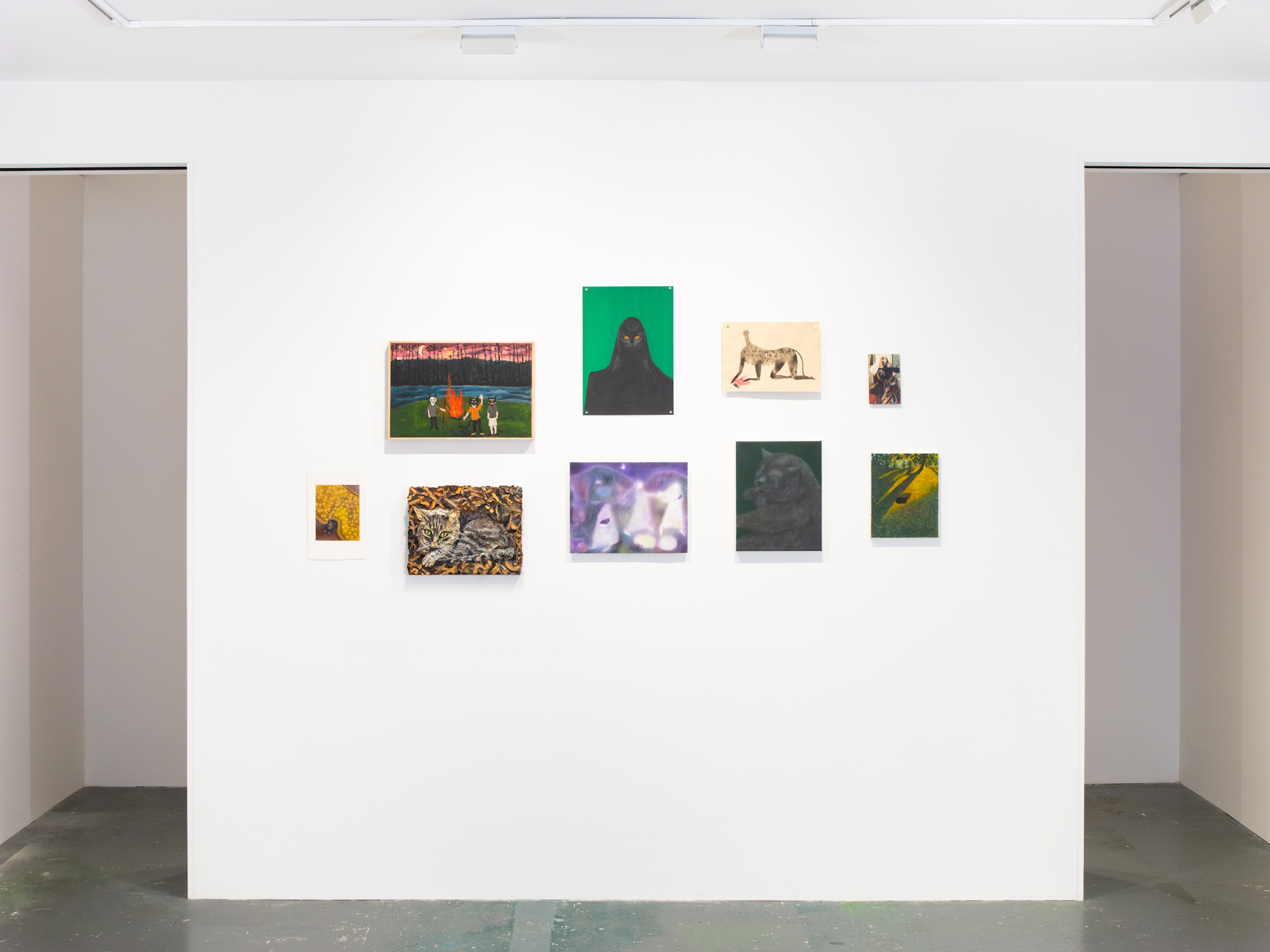 installation view of nine lives show at fortnight institute in nyc - white wall with various paintings of animals