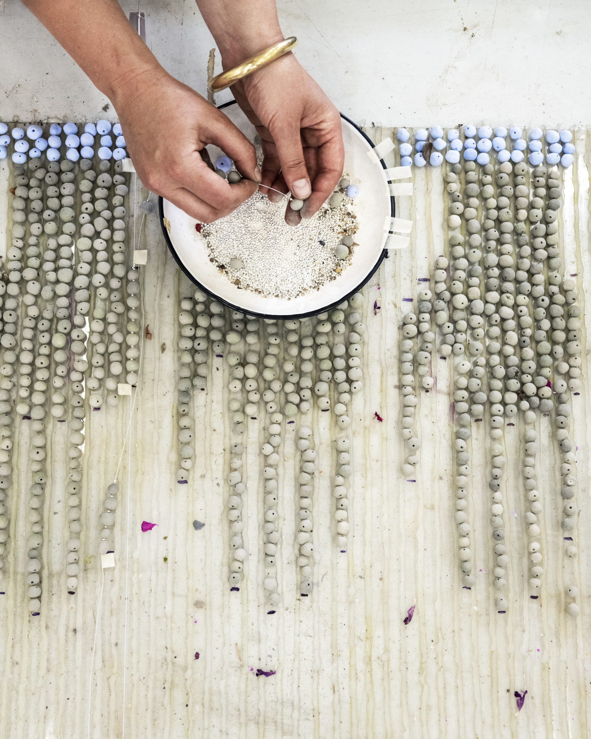 Artist Zoë Paul at work with ceramic beads. All photography courtesy of diptyque Paris.