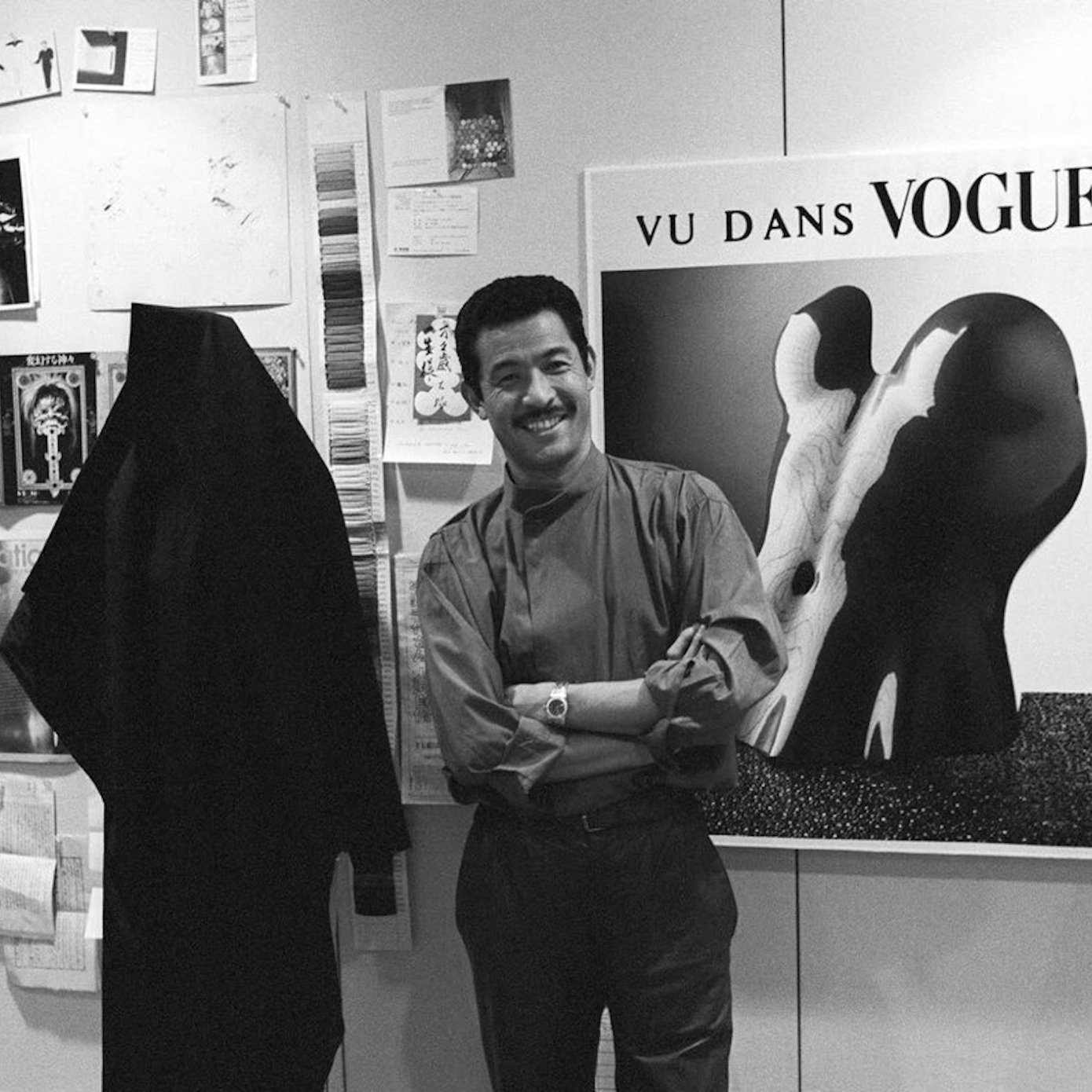 designer issey miyake stands in front of photo wall in studio
