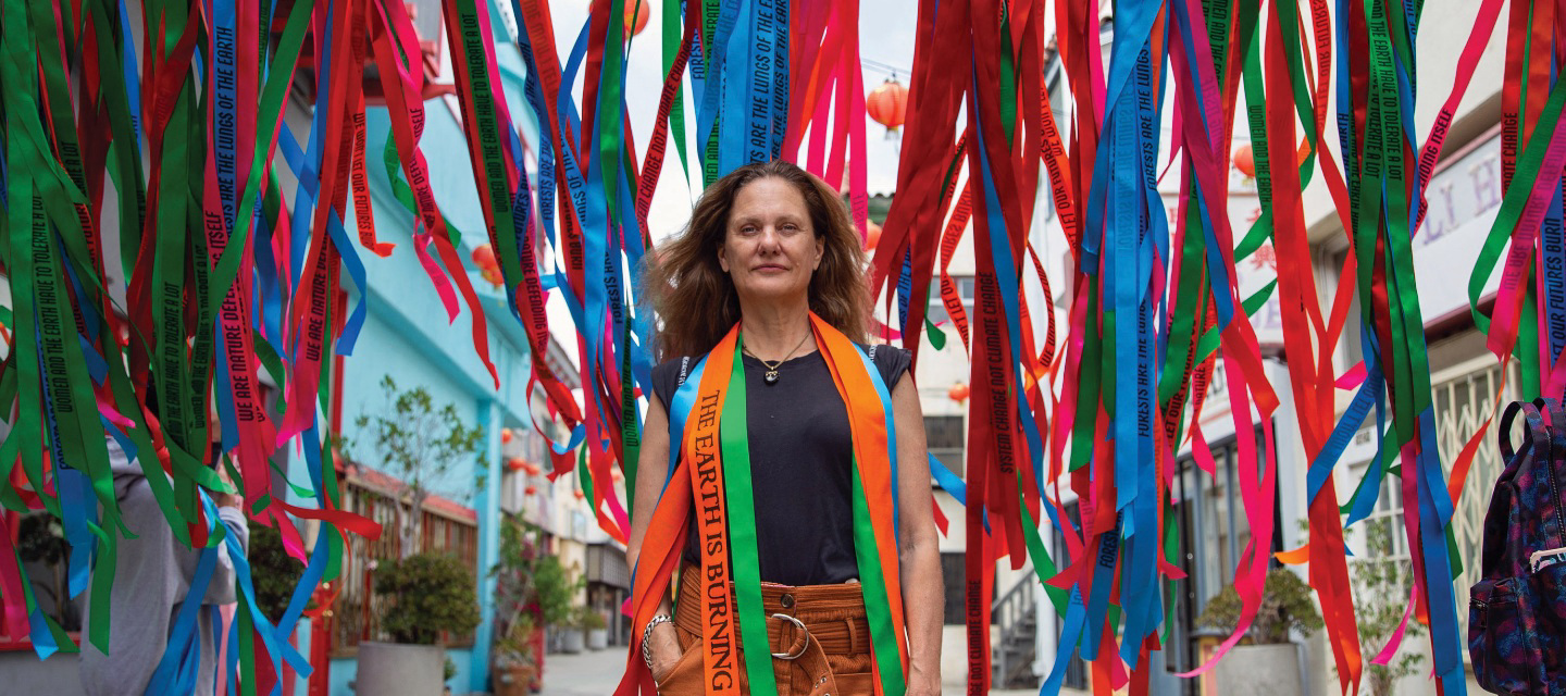 A woman standing in front of ribbons hanging down.