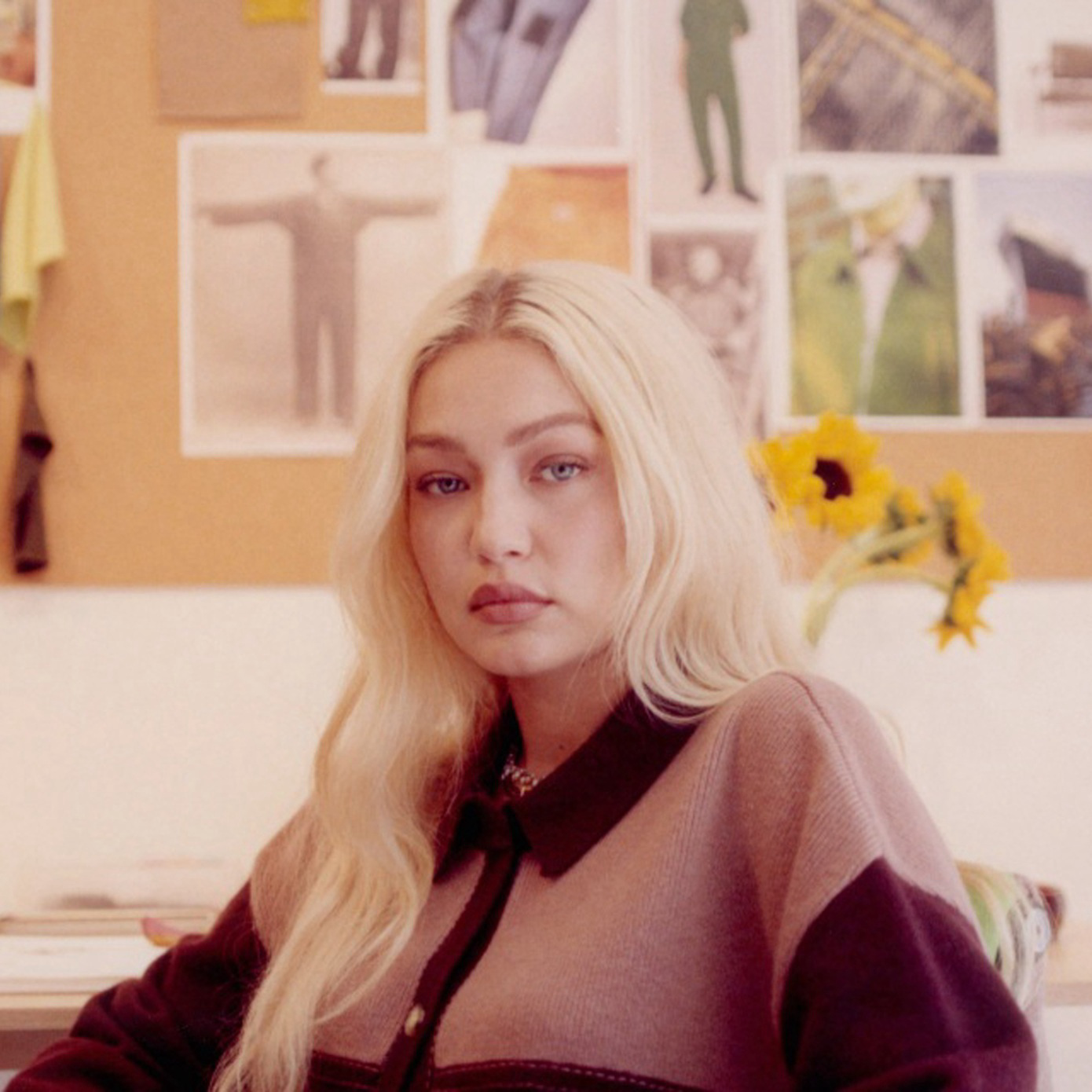 Gigi Hadid sitting in a design studio.