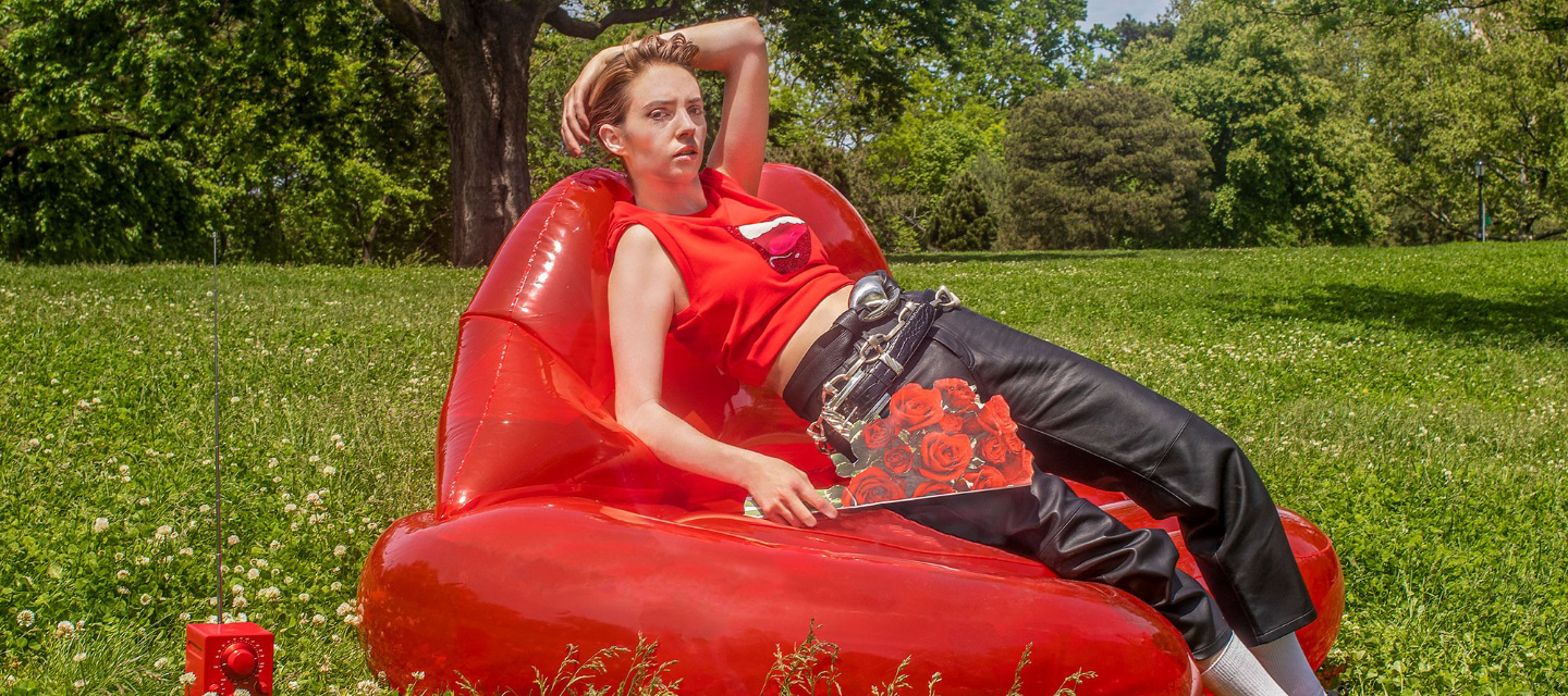 woman lays on inflatable chair on in greenery