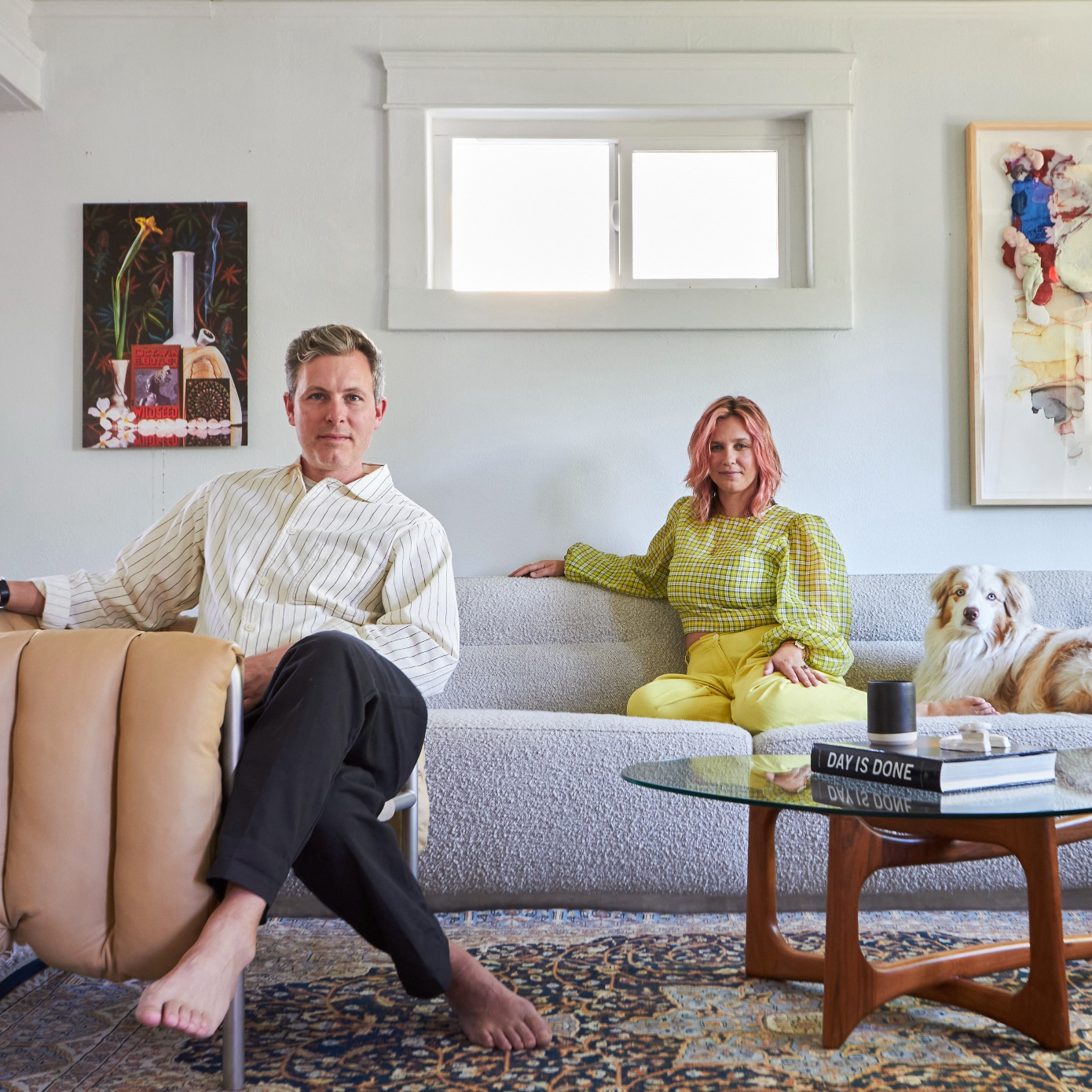 A man, woman and dog sitting in a living room.
