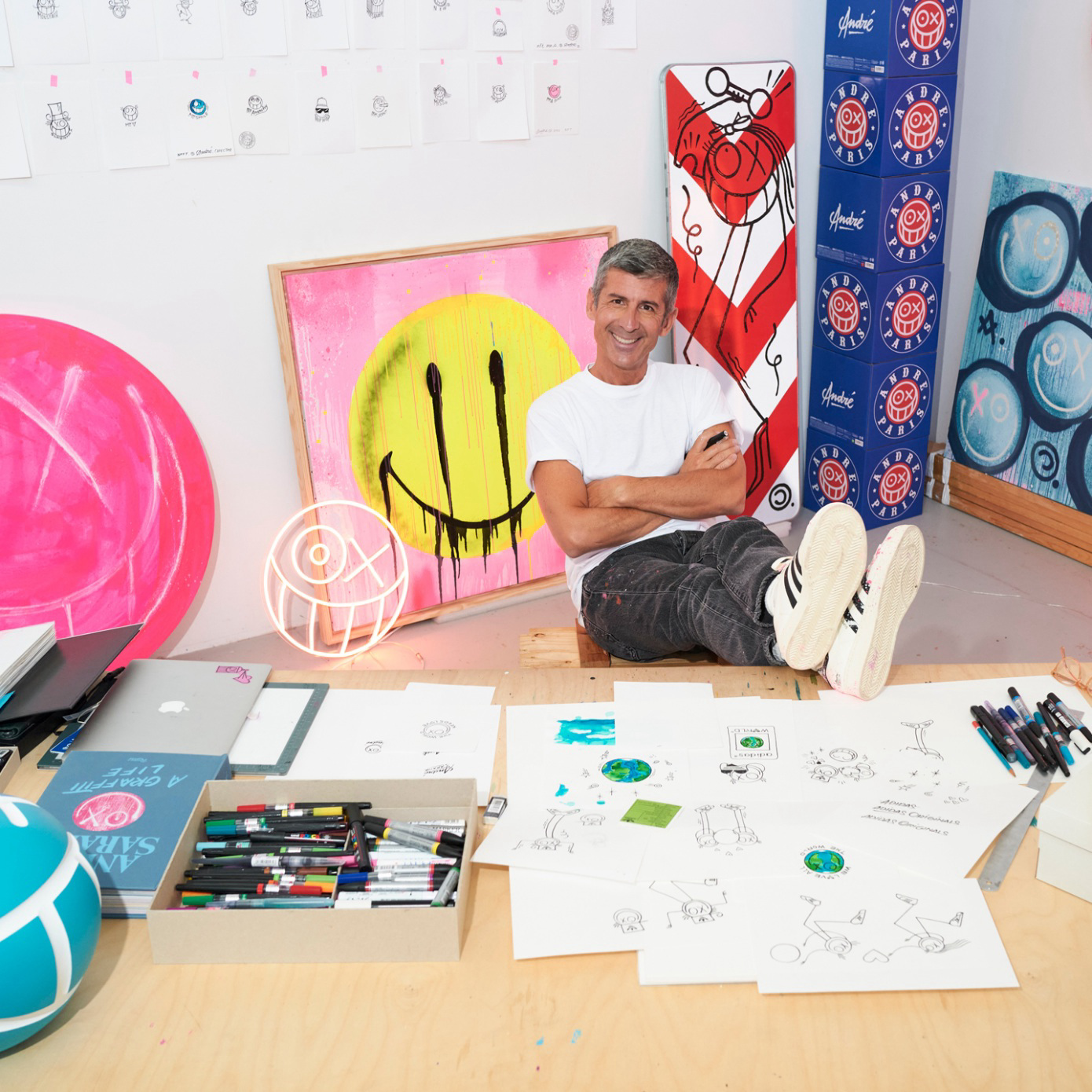 André Saraiva in his studio on the floor surrounded by art.