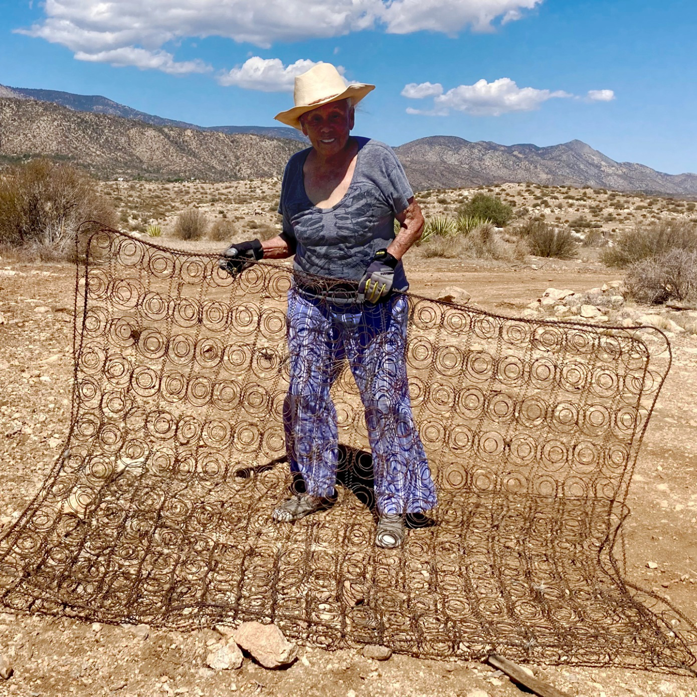 A woman holding a wired fence.