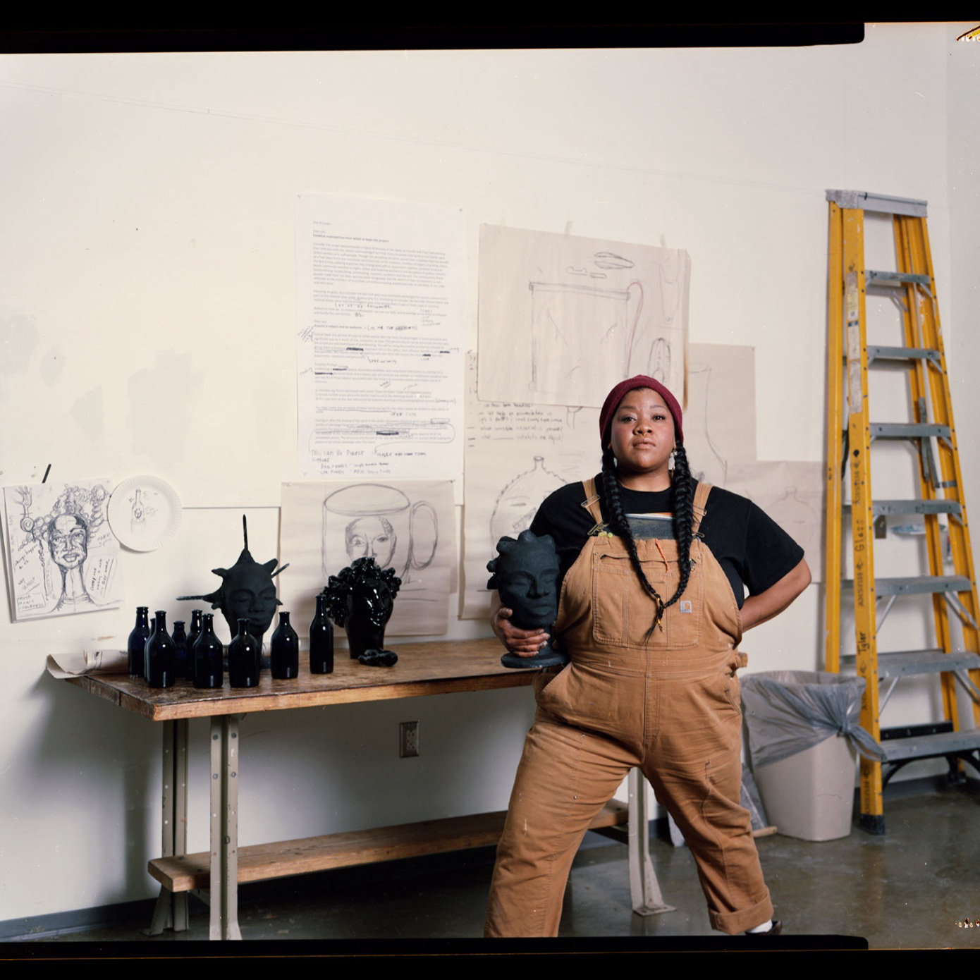woman standing in studio with sculptures