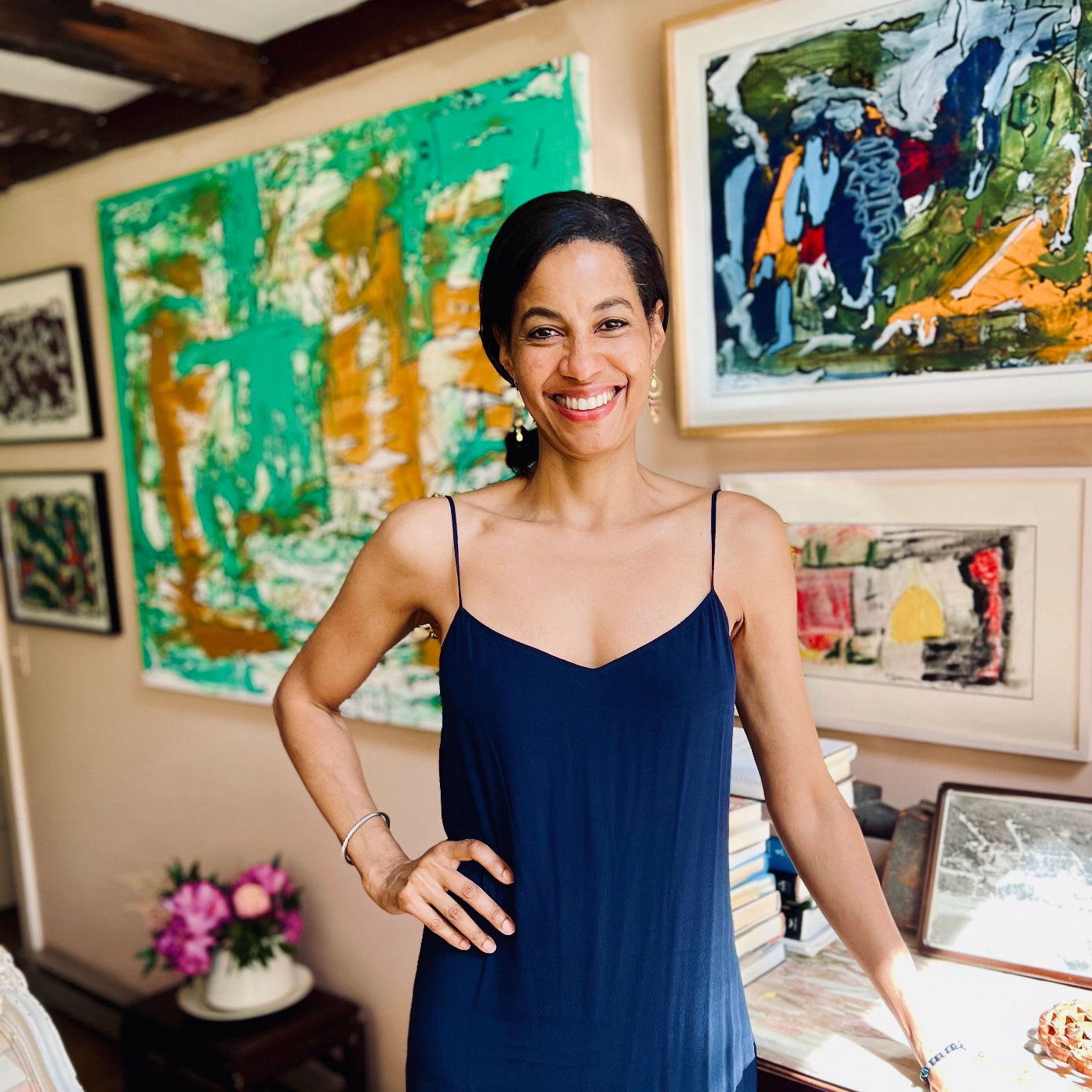 Woman smiling in front of paintings.