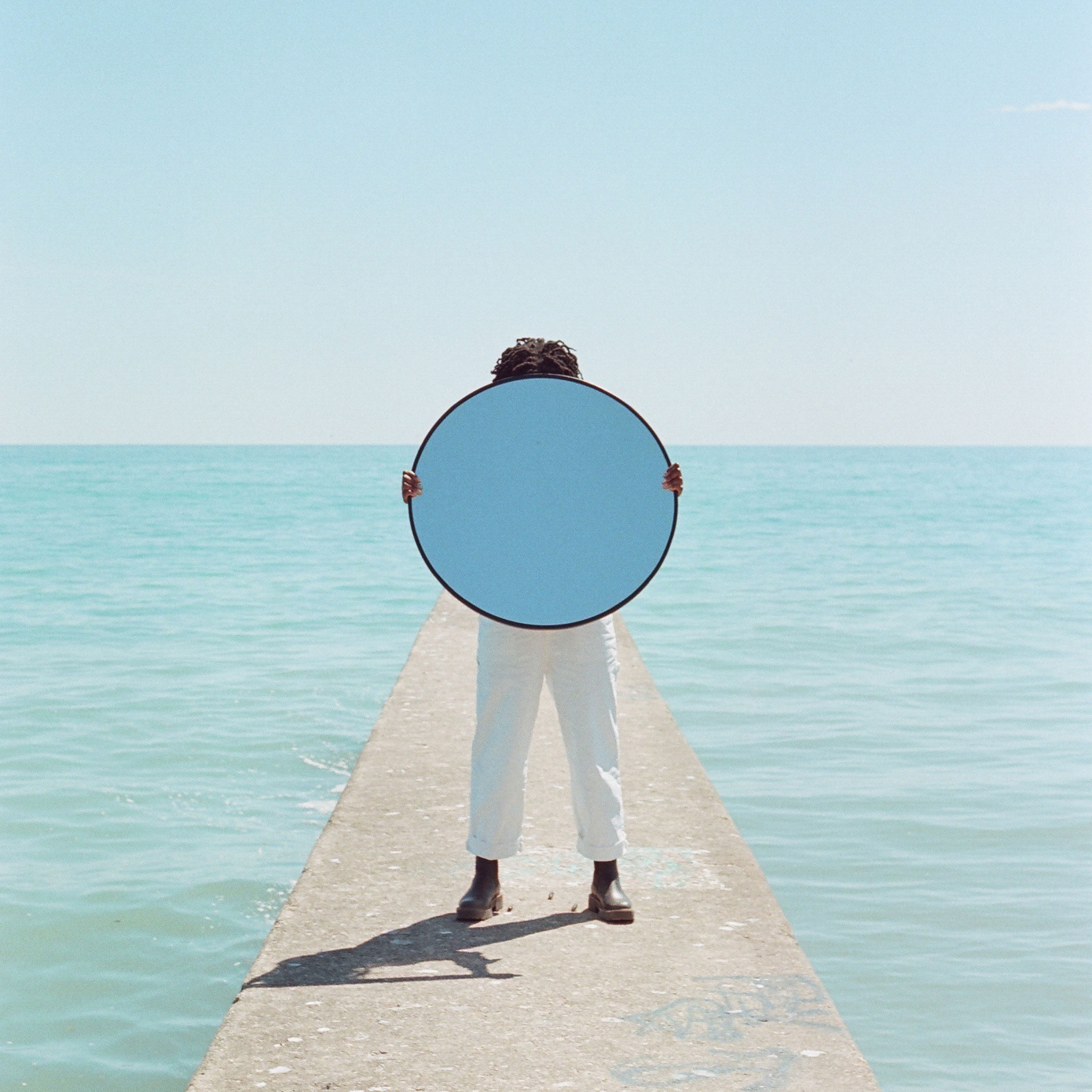 person with mirror by sea