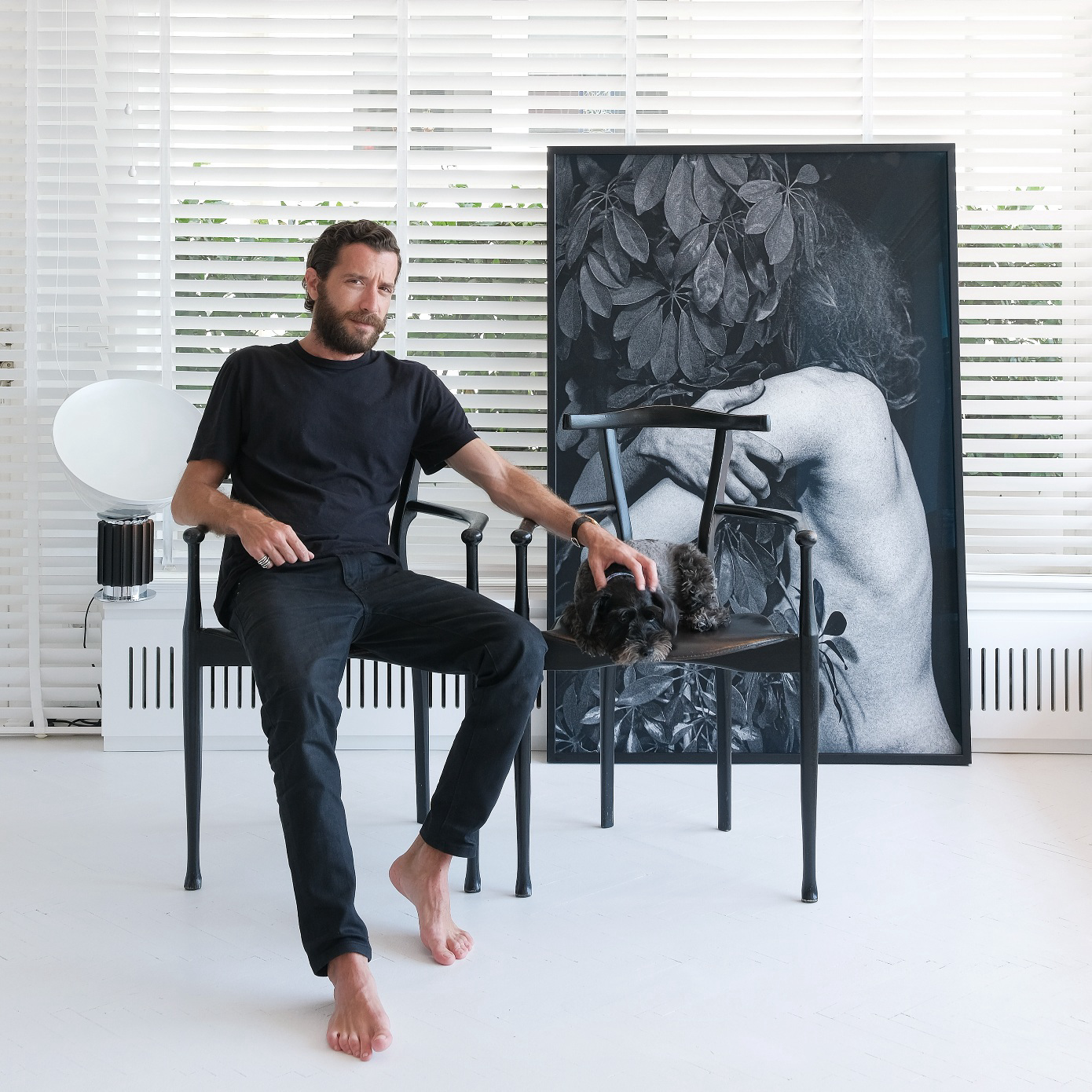 Man sitting in a chair in front of a photo.