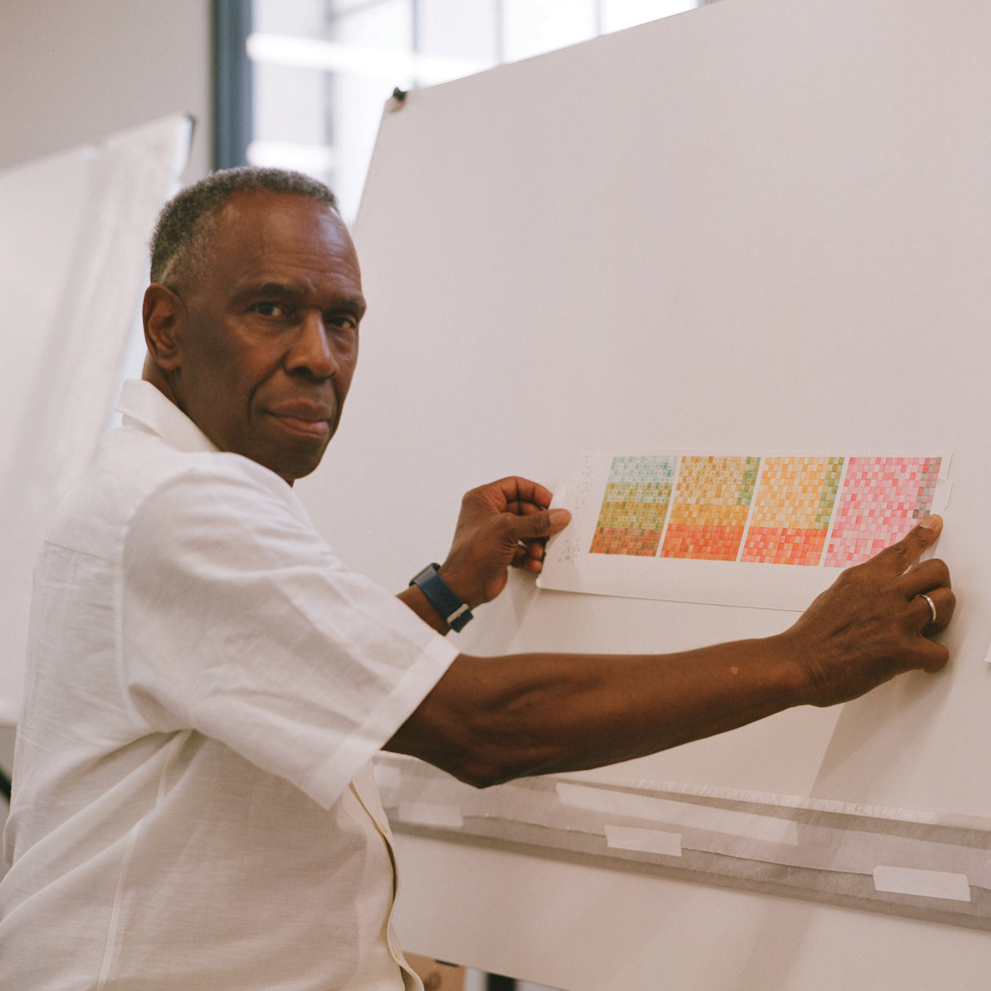 Charles Gaines sitting in front of an easel.