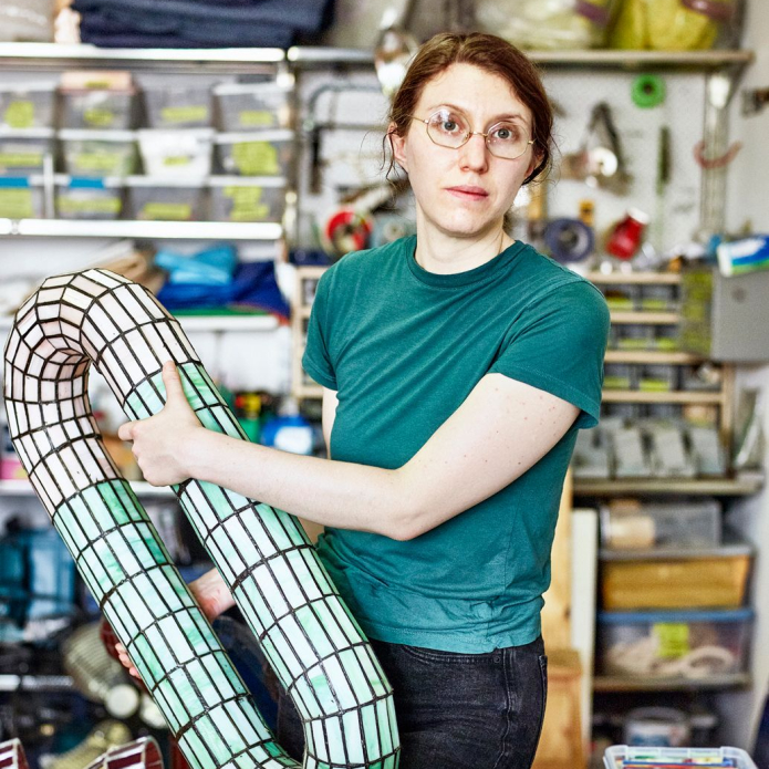 person standing with sculpture in studio