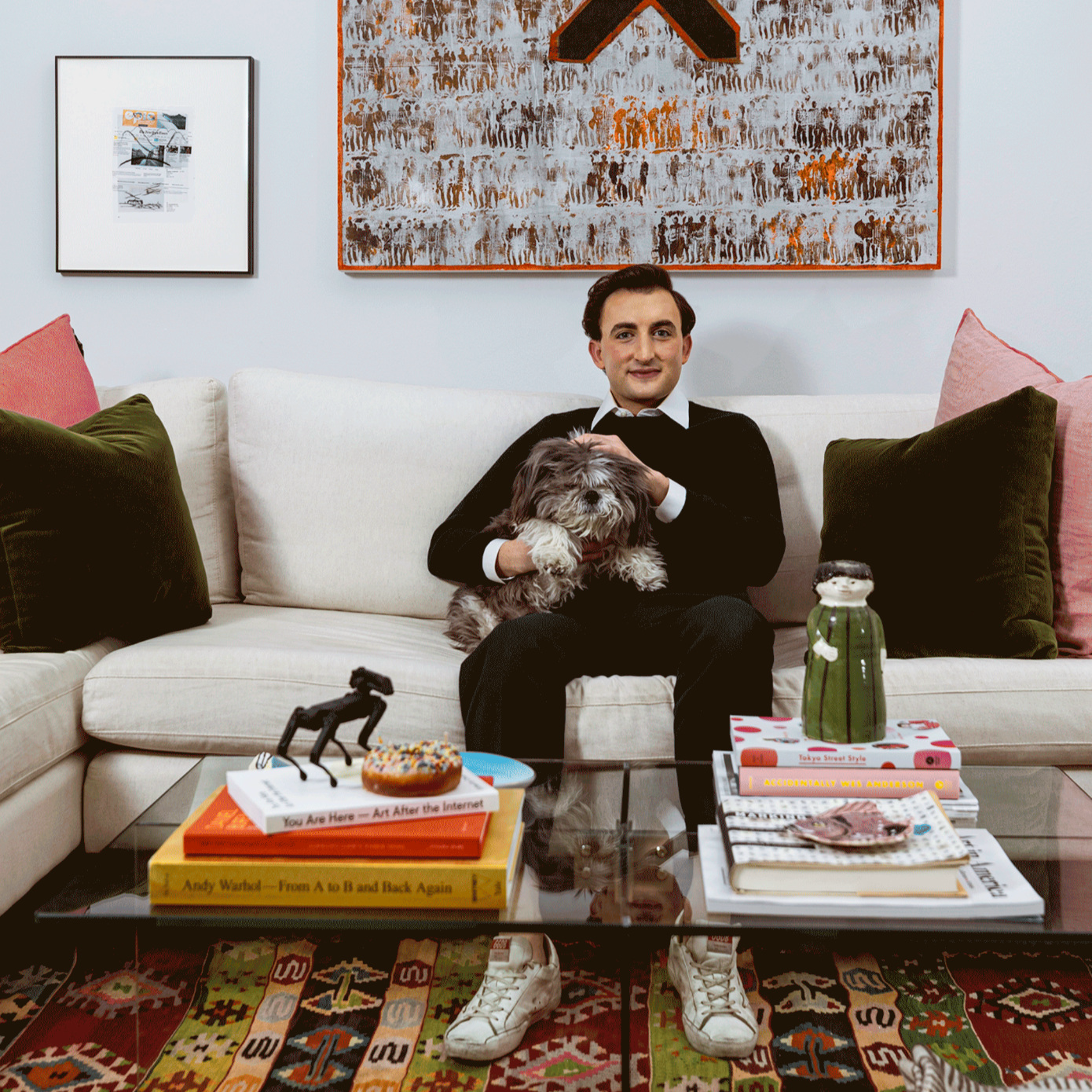 man on sofa with dog and art