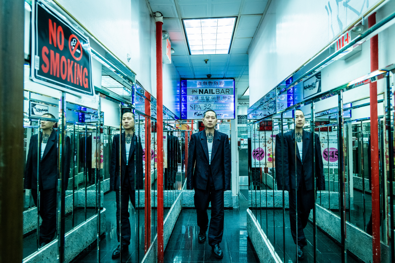 Man standing in a mirrored hallway.