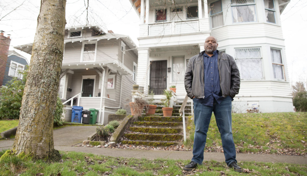 man standing in front of a house