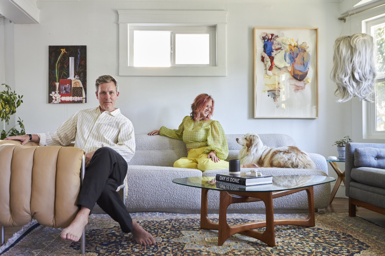 Man and woman sitting in the living room with their dog.