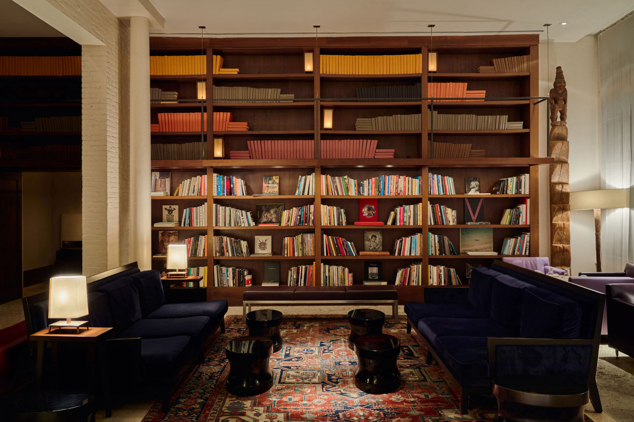 Two empty couches face each other perpendicular to a bookshelf