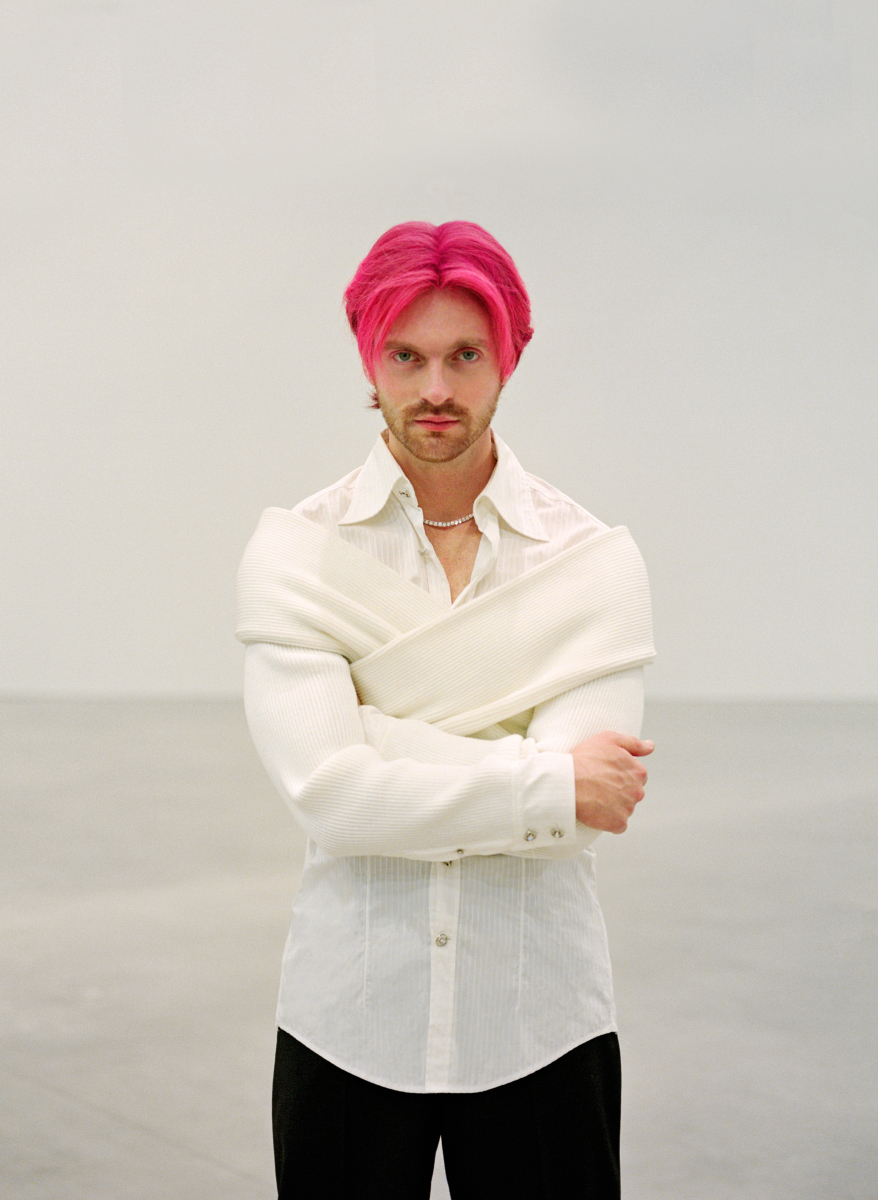 man standing in shirt with pink hair