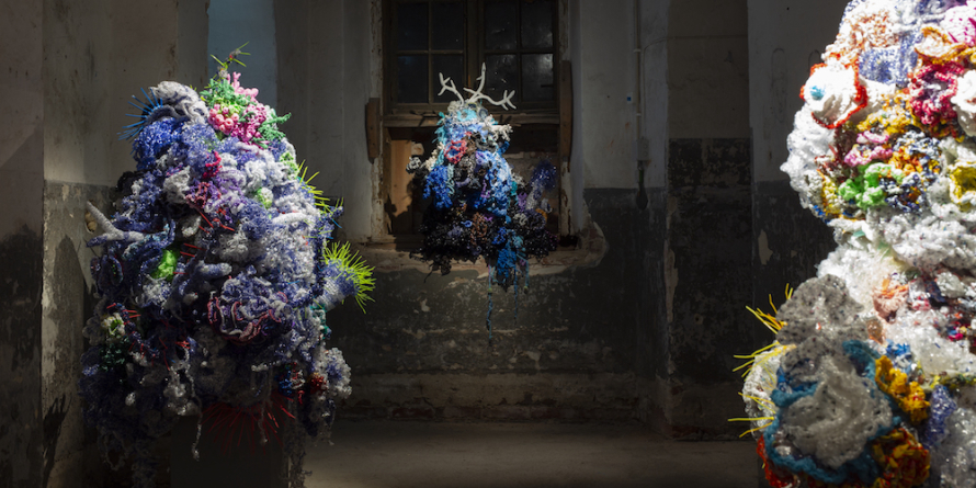 colorful coral reef-like sculptures in unfinished, rough space