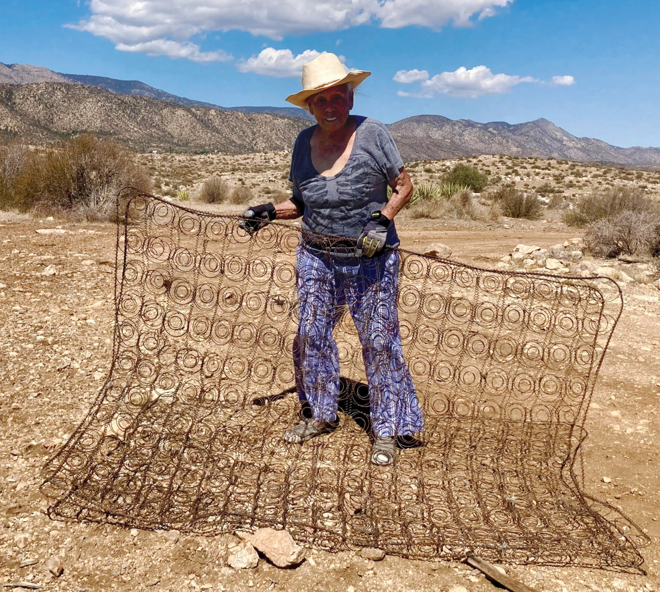 A woman outside holding a wire frame.