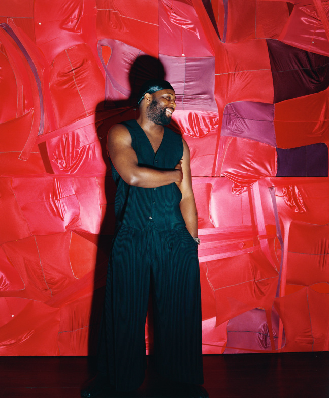 man standing against red wall