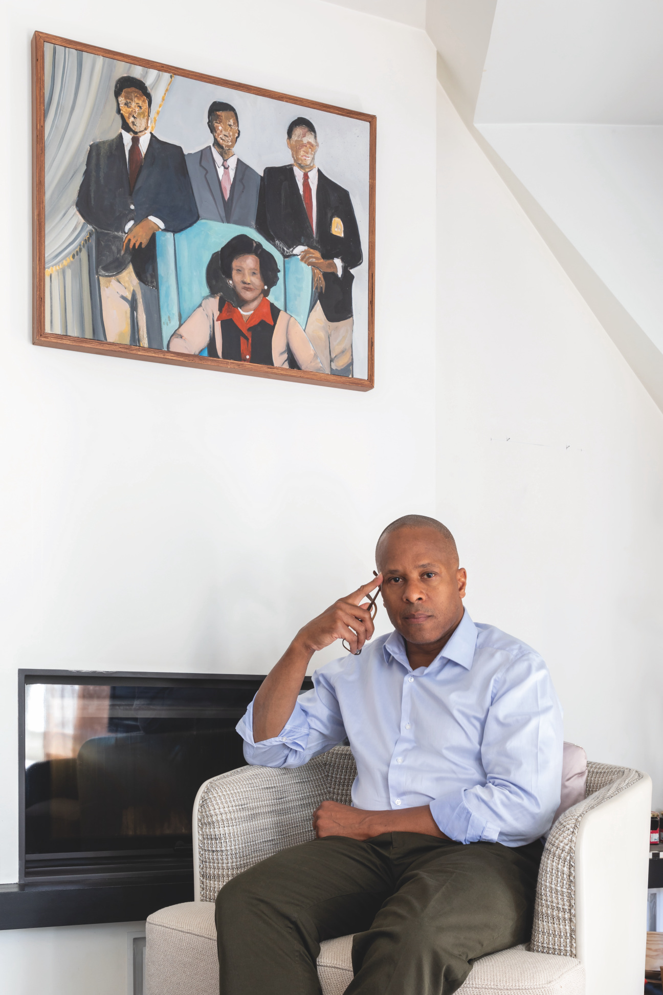 Man seated in front of a painting.